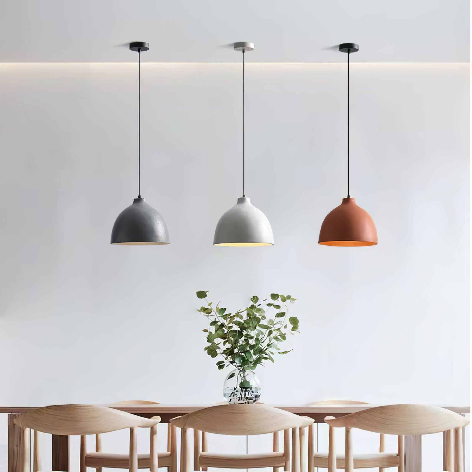 Three coloured bowl pendants above a dining table