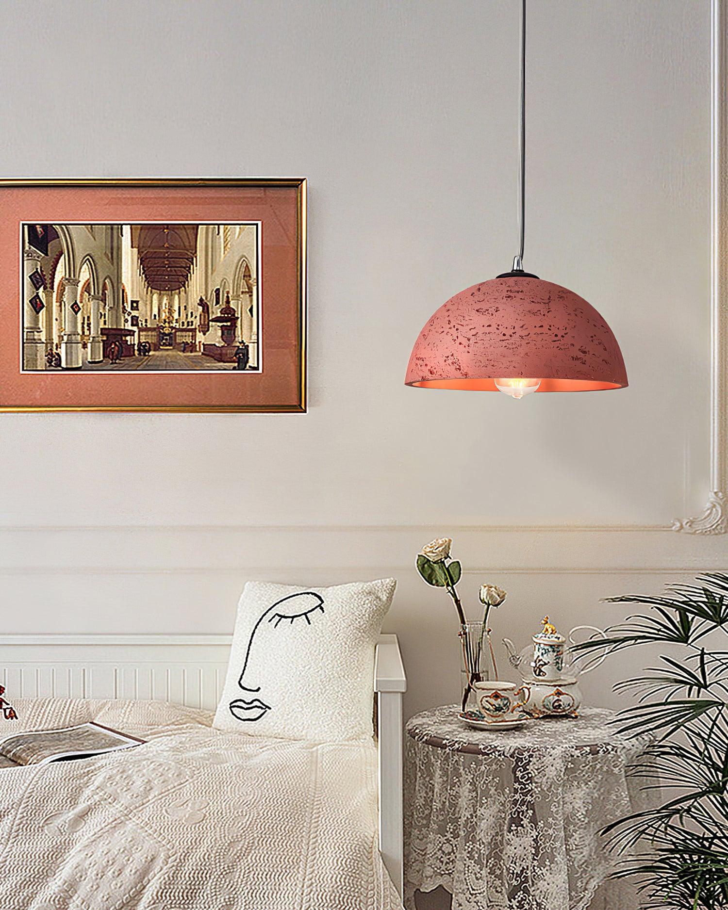 Red textured dome above seating corner with face-pattern cushion, framed picture, vase, tea set and leafy plant