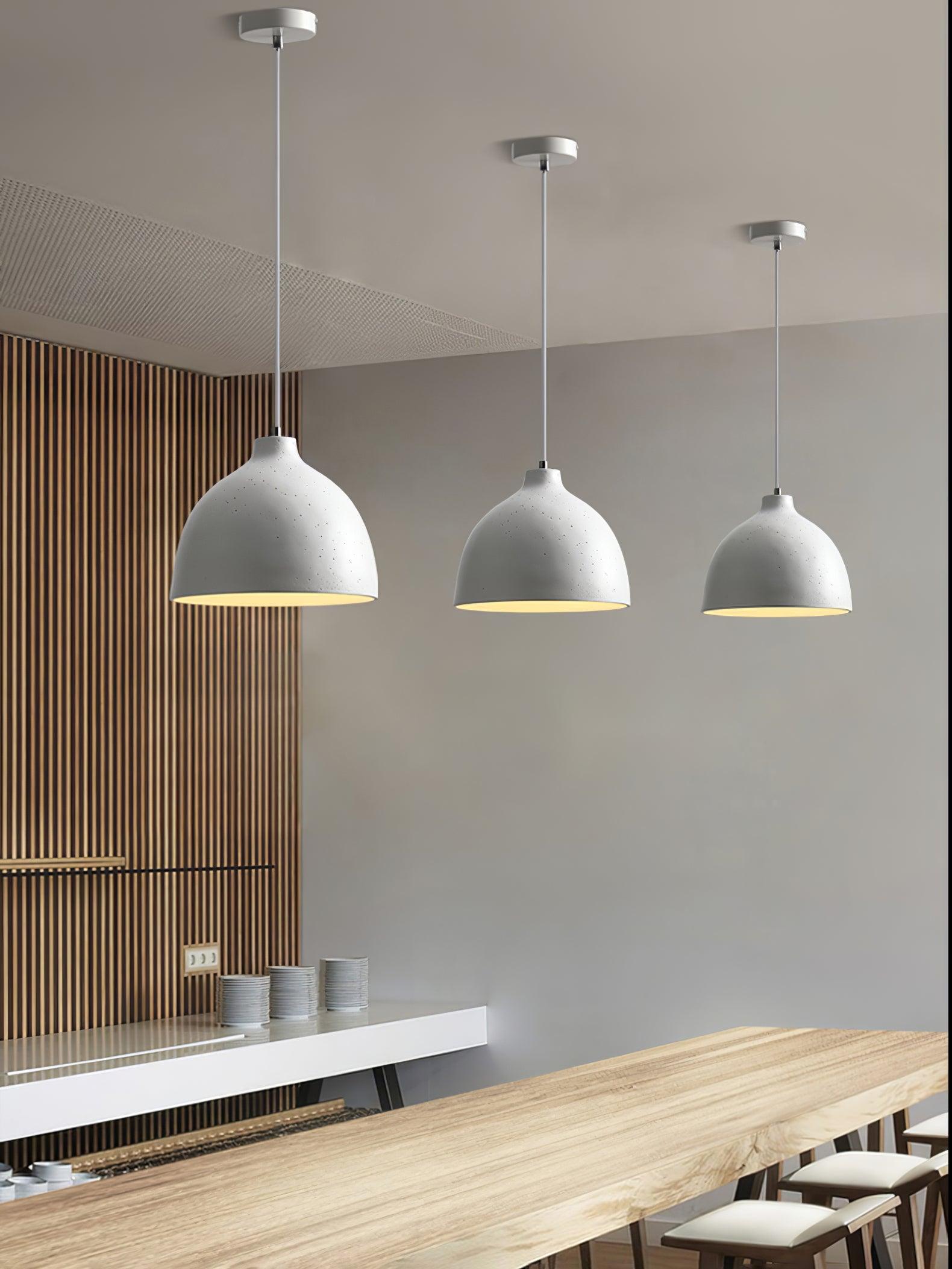 Three white pendants over a long counter