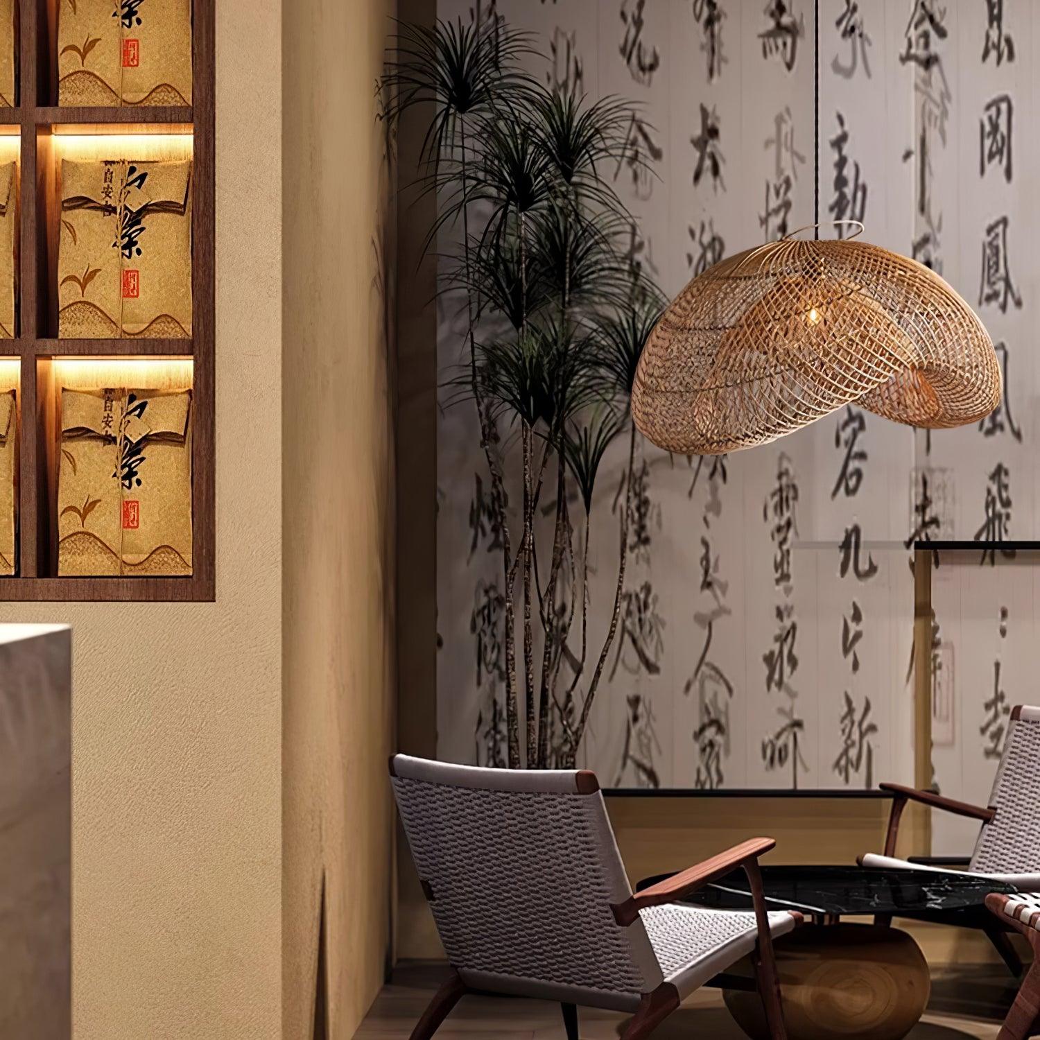 Rattan wave pendant over woven chairs and a dark side table with calligraphy panels and a tall plant