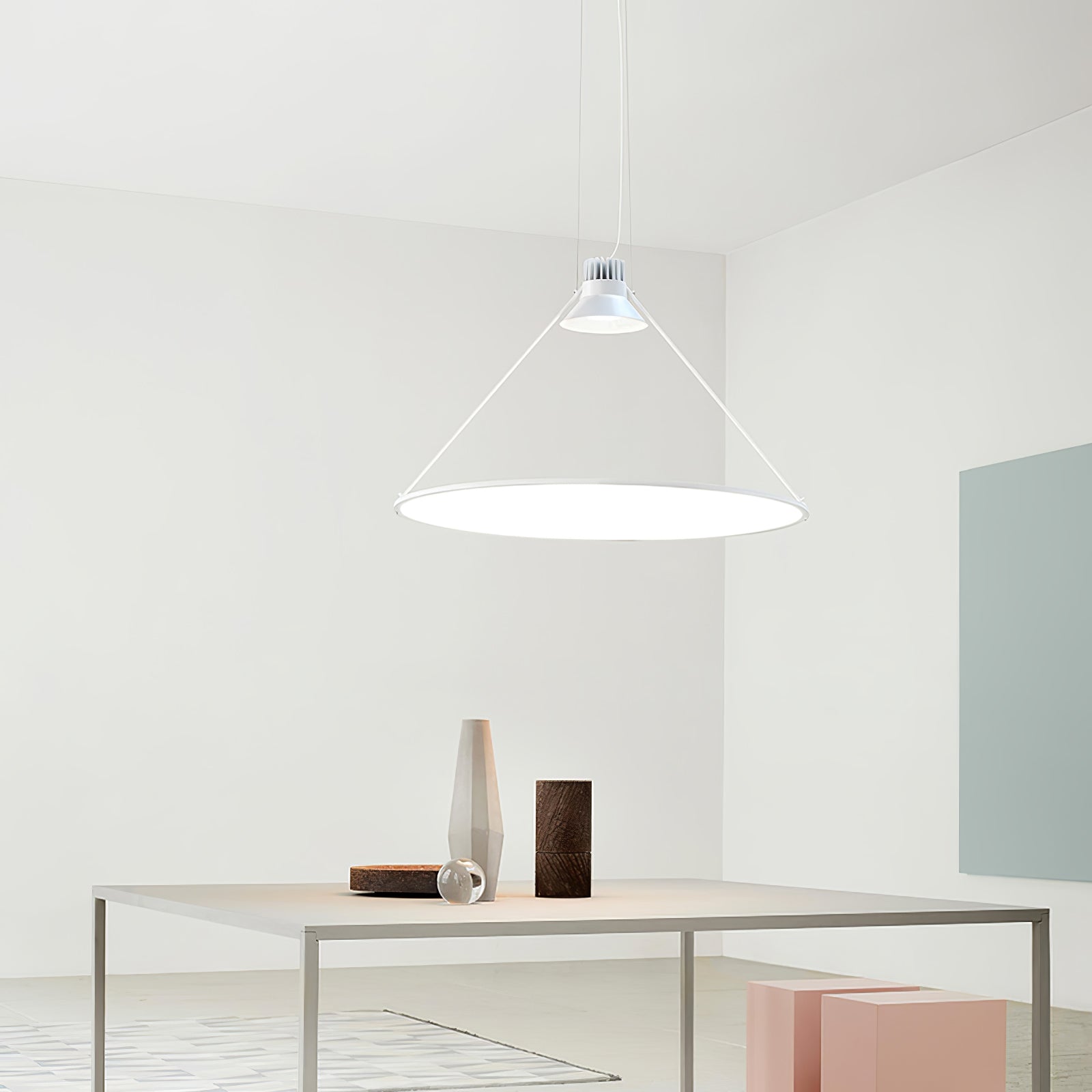 White disc above a table in a pale interior