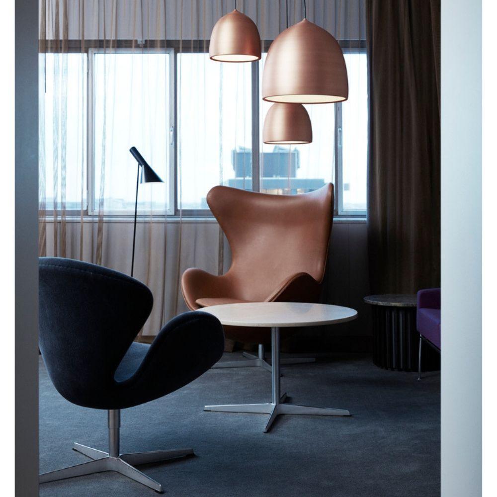 Three copper-coloured pendants beside a window
