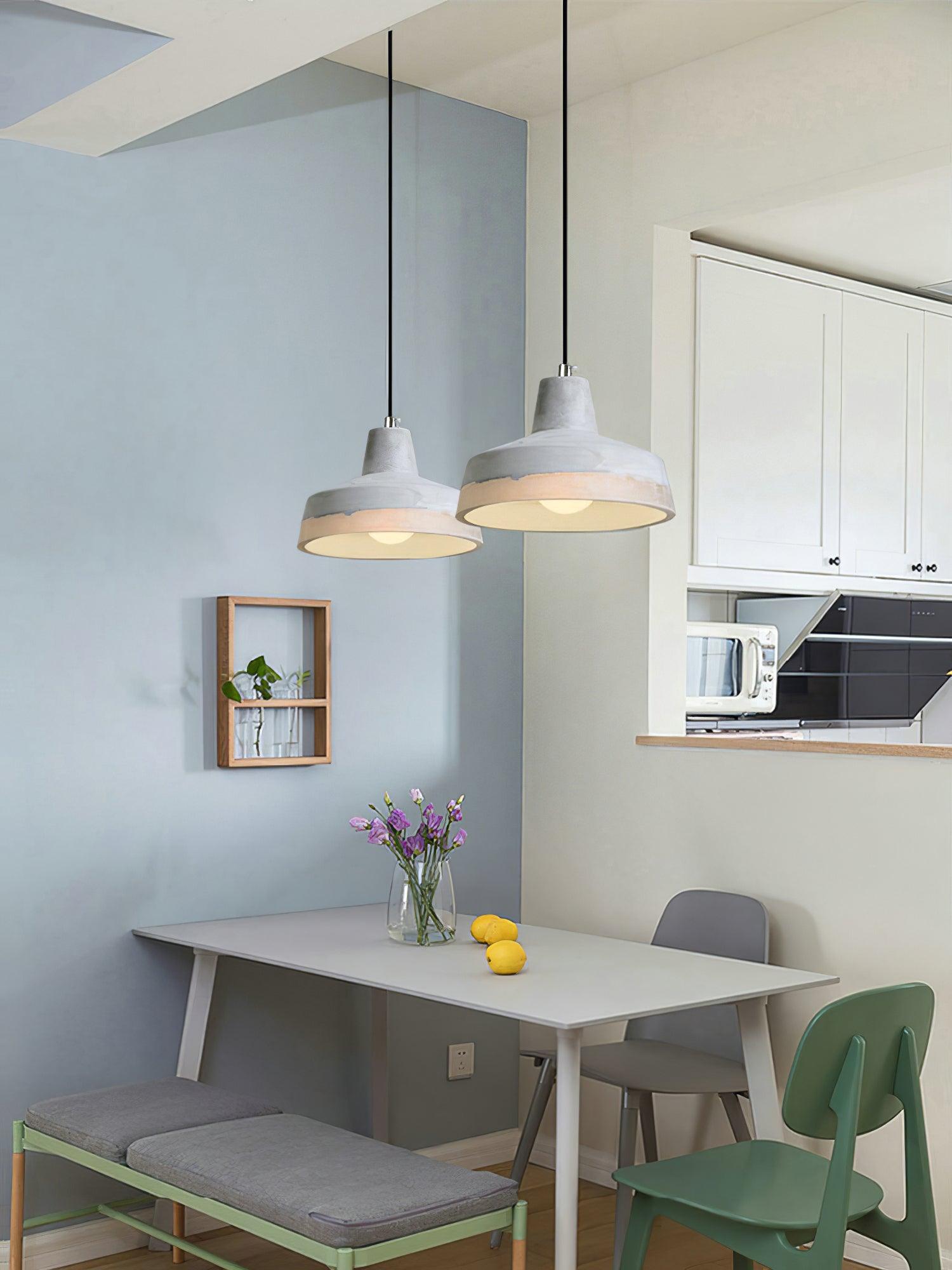 Broad grey pendants above a compact dining corner