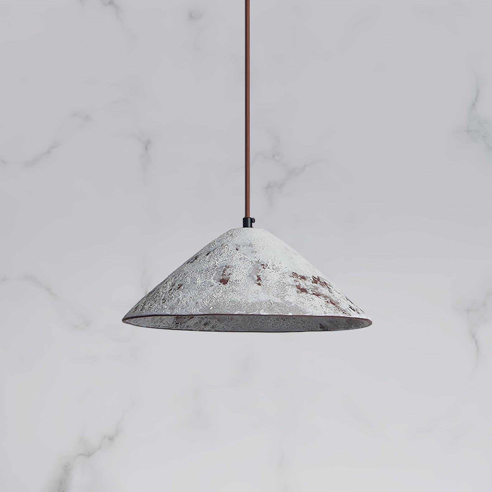 White mottled ceramic cone with a grey-looking interior and brown cord against a pale veined background