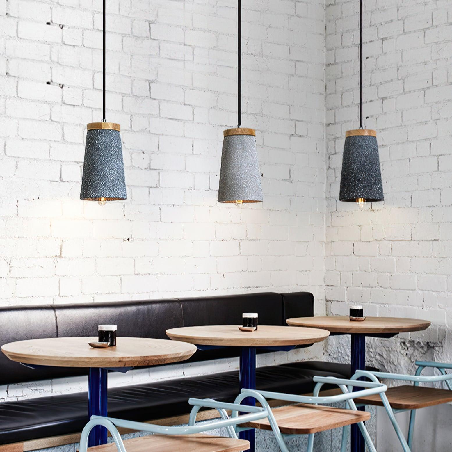 Three wood-topped pendants against a brick wall