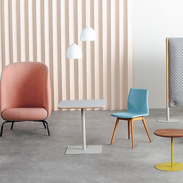 White pendants beside pink and blue chairs