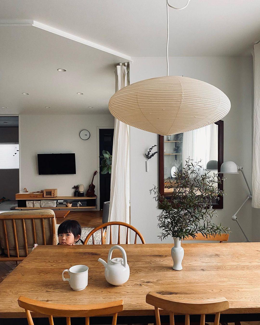 Wide ribbed paper shade over a dining table with cups