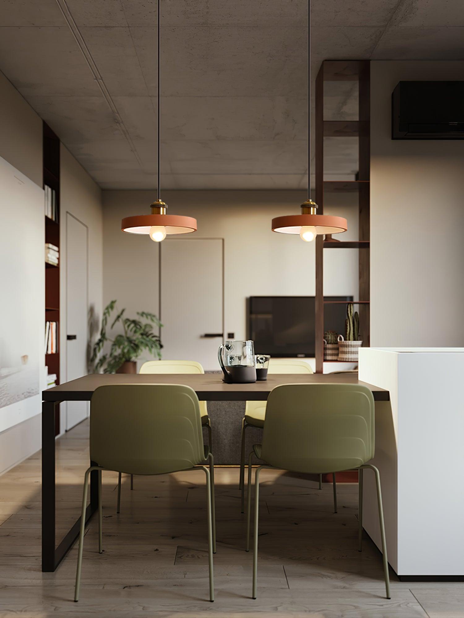 Two orange disc pendants above a dining table in a kitchen interior