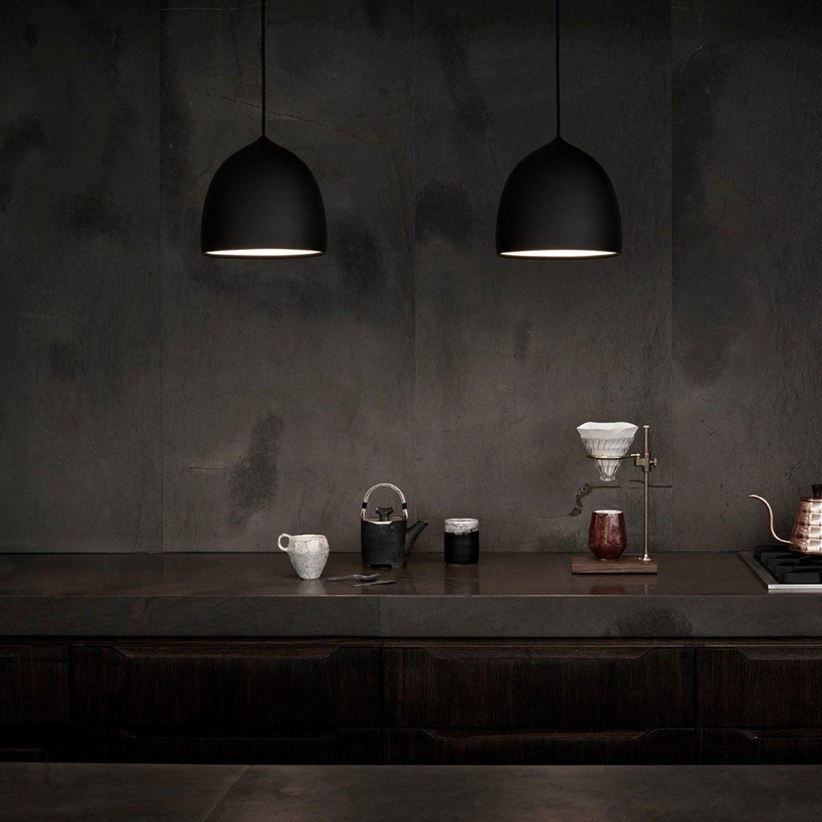 Two lit black bell shades above a dark counter
