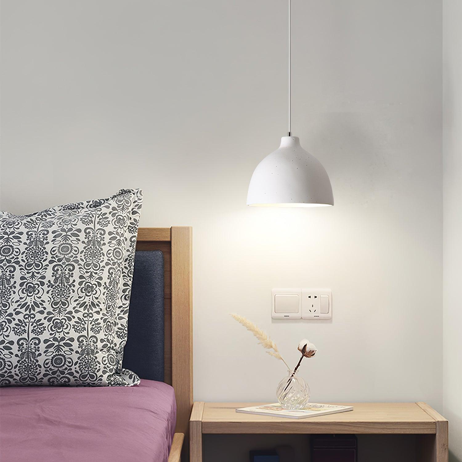 White pendant beside an upholstered bed