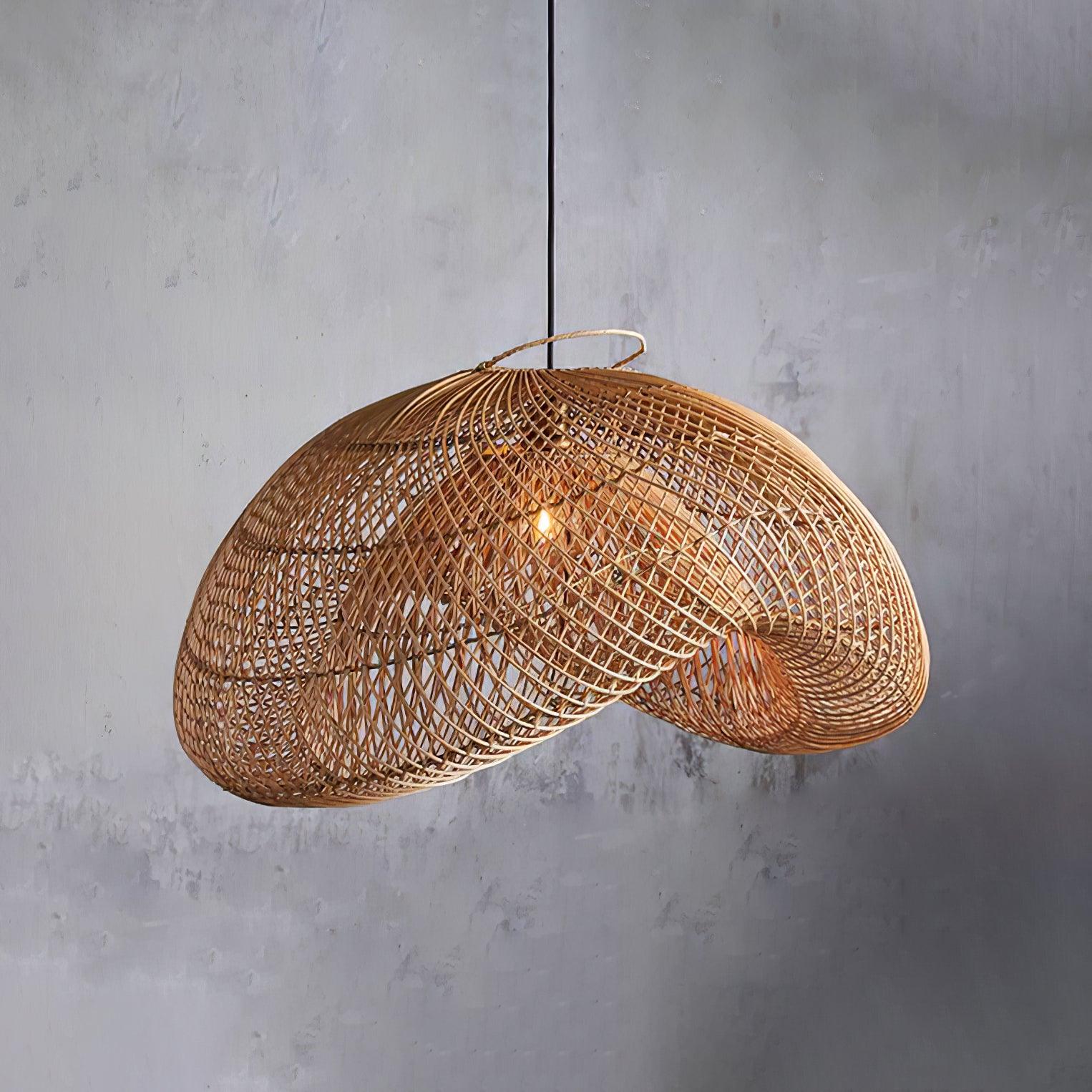 Glowing rattan wave shade with open lattice, curved rim, top loop and black cord against a textured grey wall