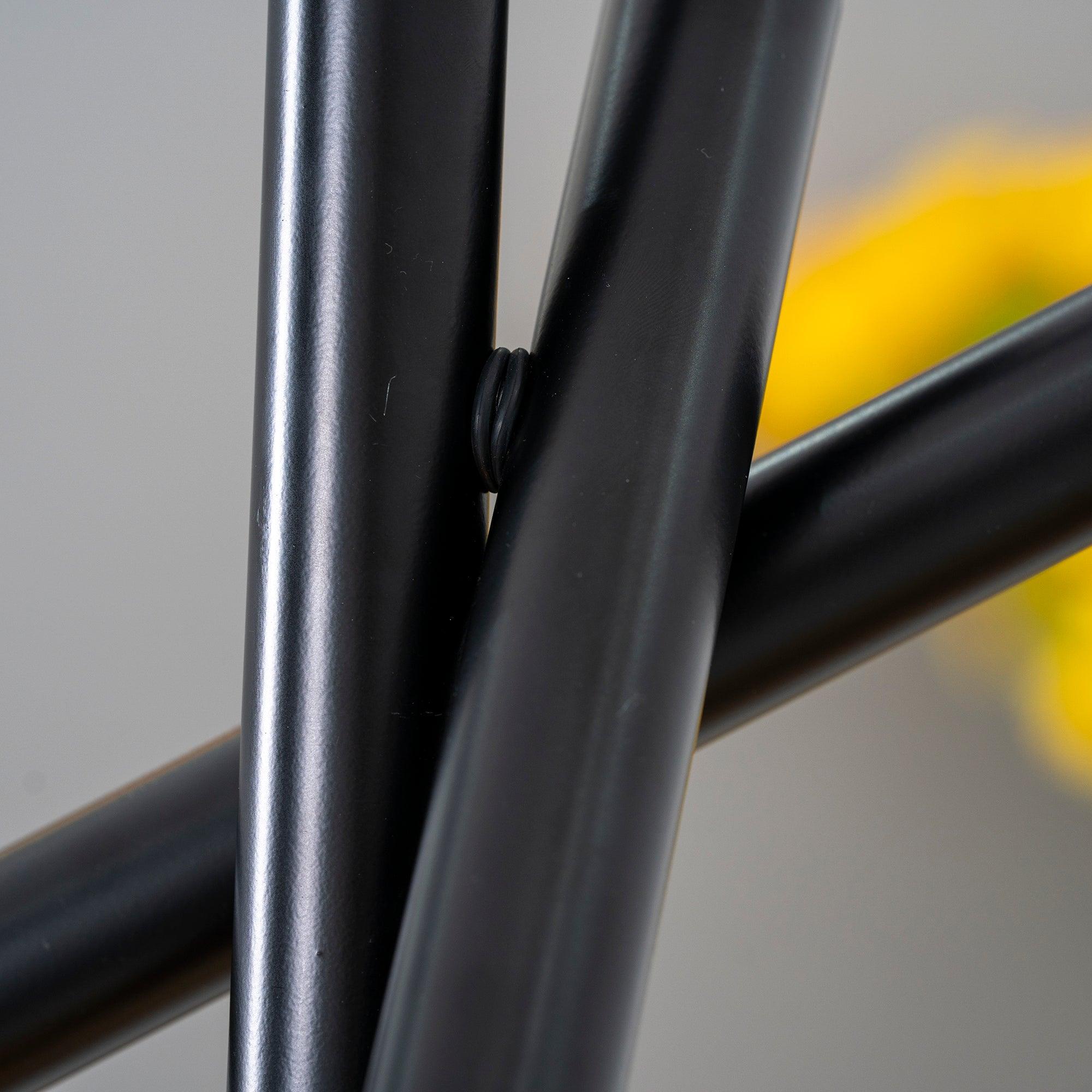 Close-up of the joint between intersecting black Tubes cylinders
