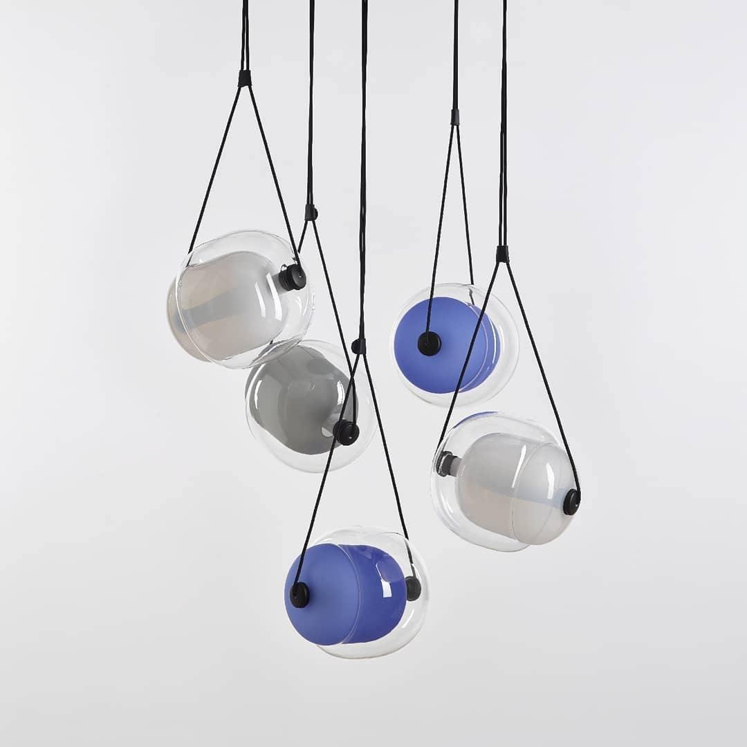 Clear and blue layered glass pendants on dark straps