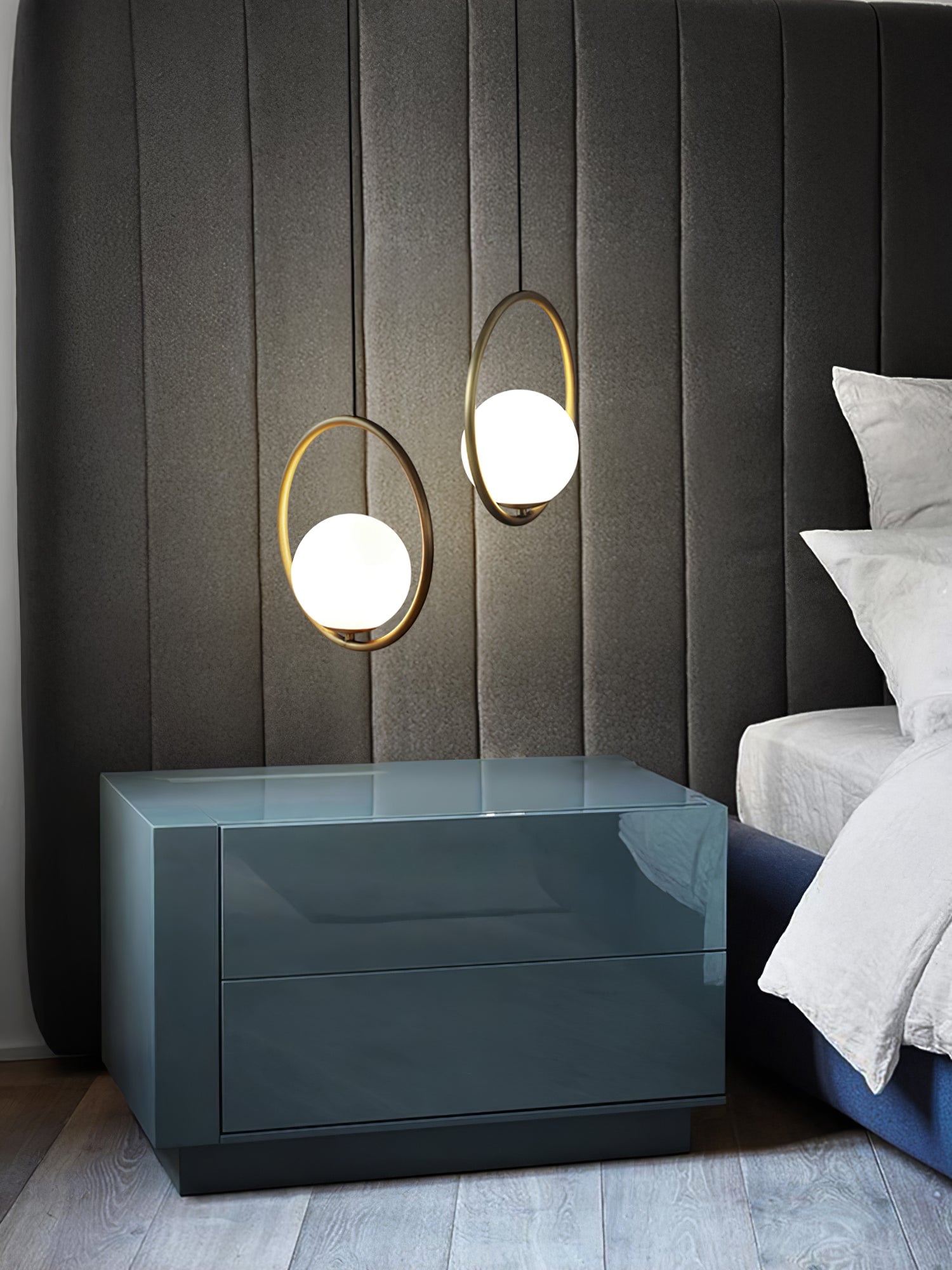 Oval and circular globe pendants above a blue bedside cabinet