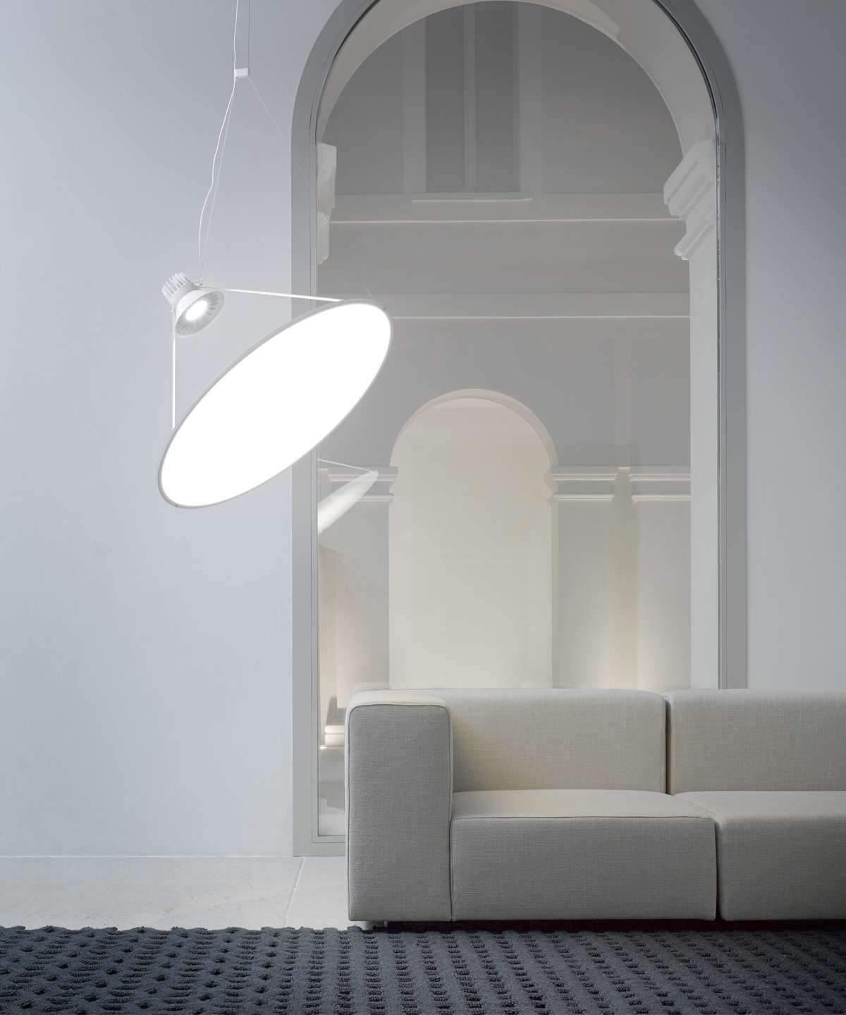 Pale glowing disc beside a sofa and archway