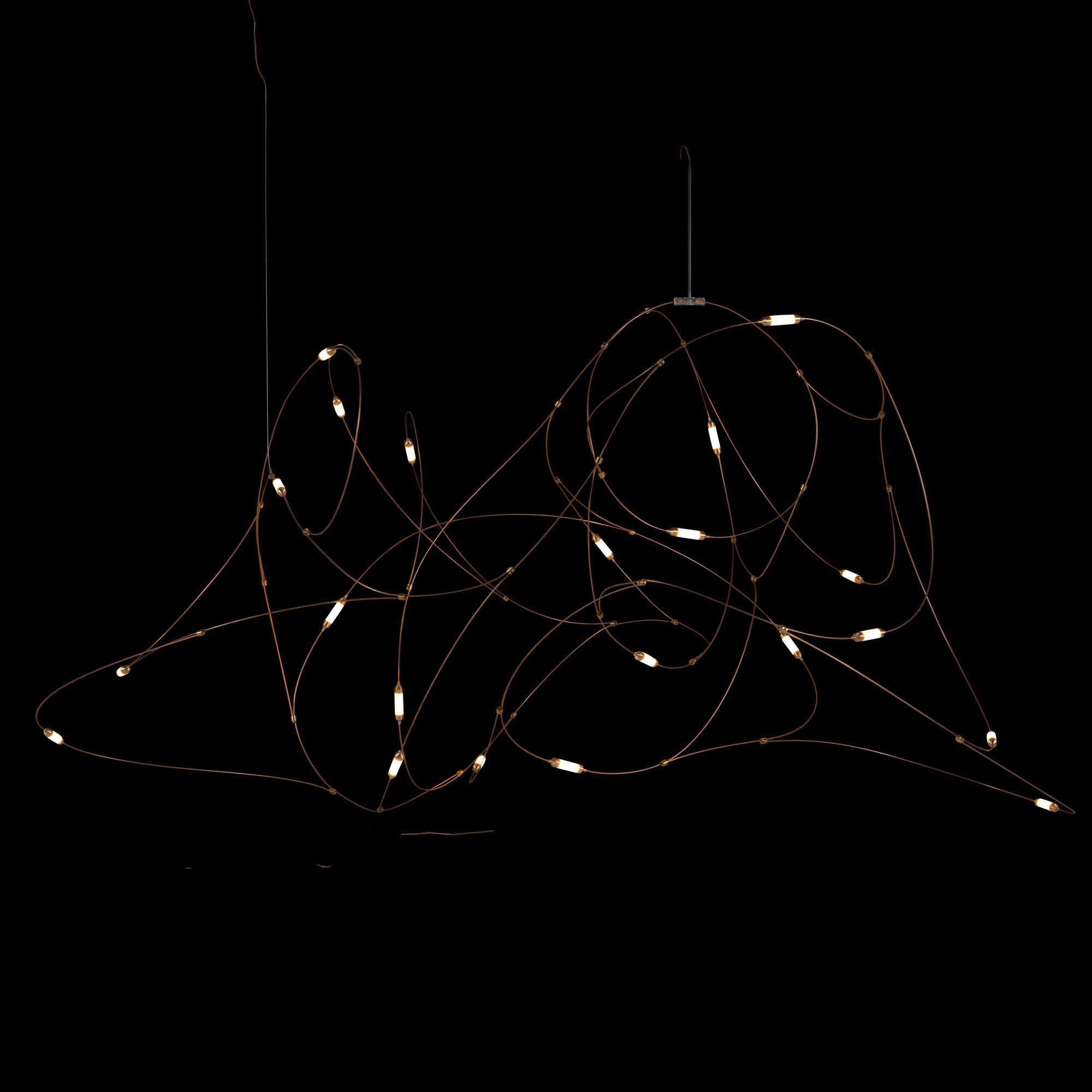 Wide gold-tone wire-loop pendant with small glowing cylindrical diffusers on black
