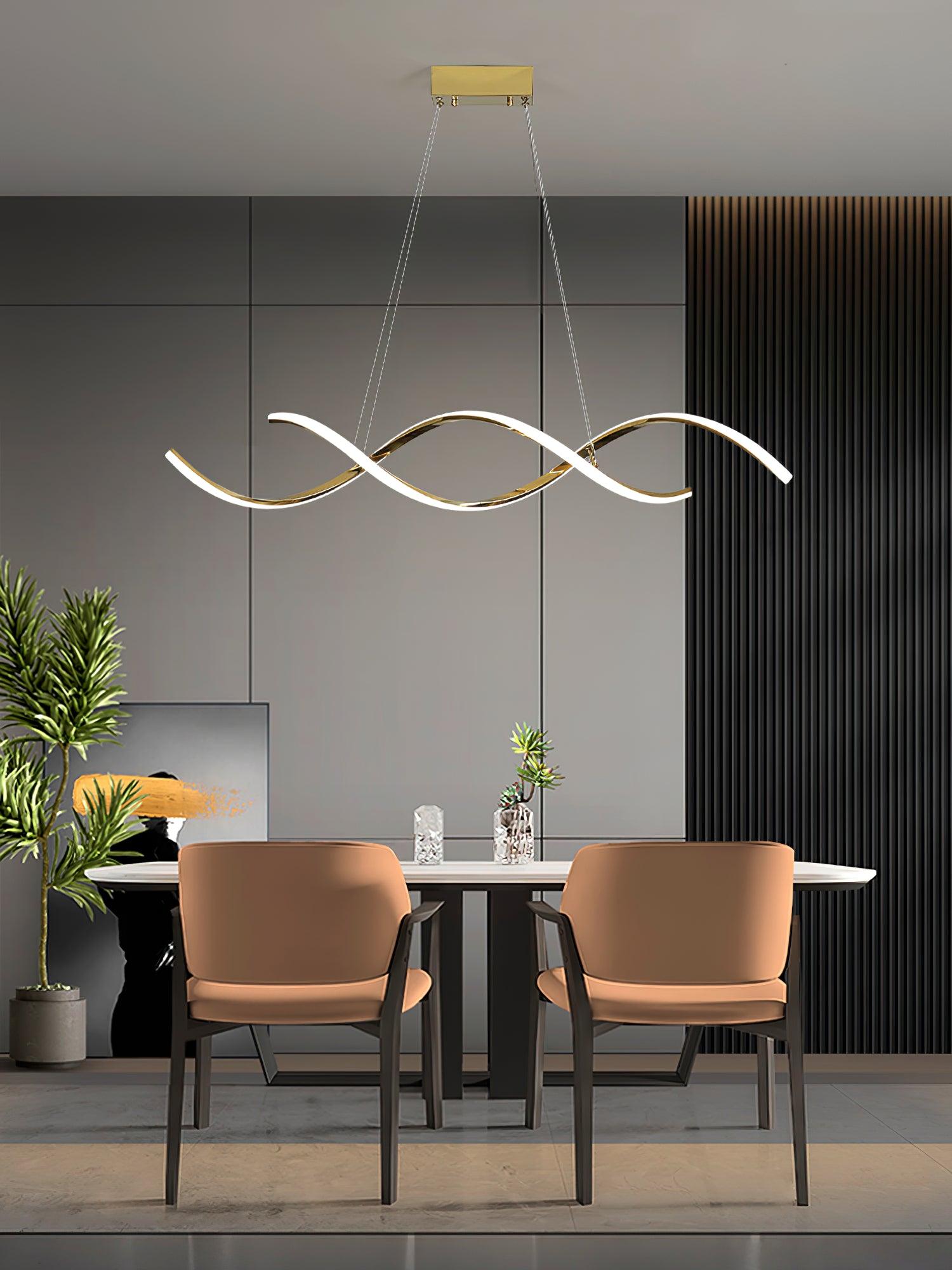 Gold wave pendant above a table with two orange chairs and plants against a grey wall