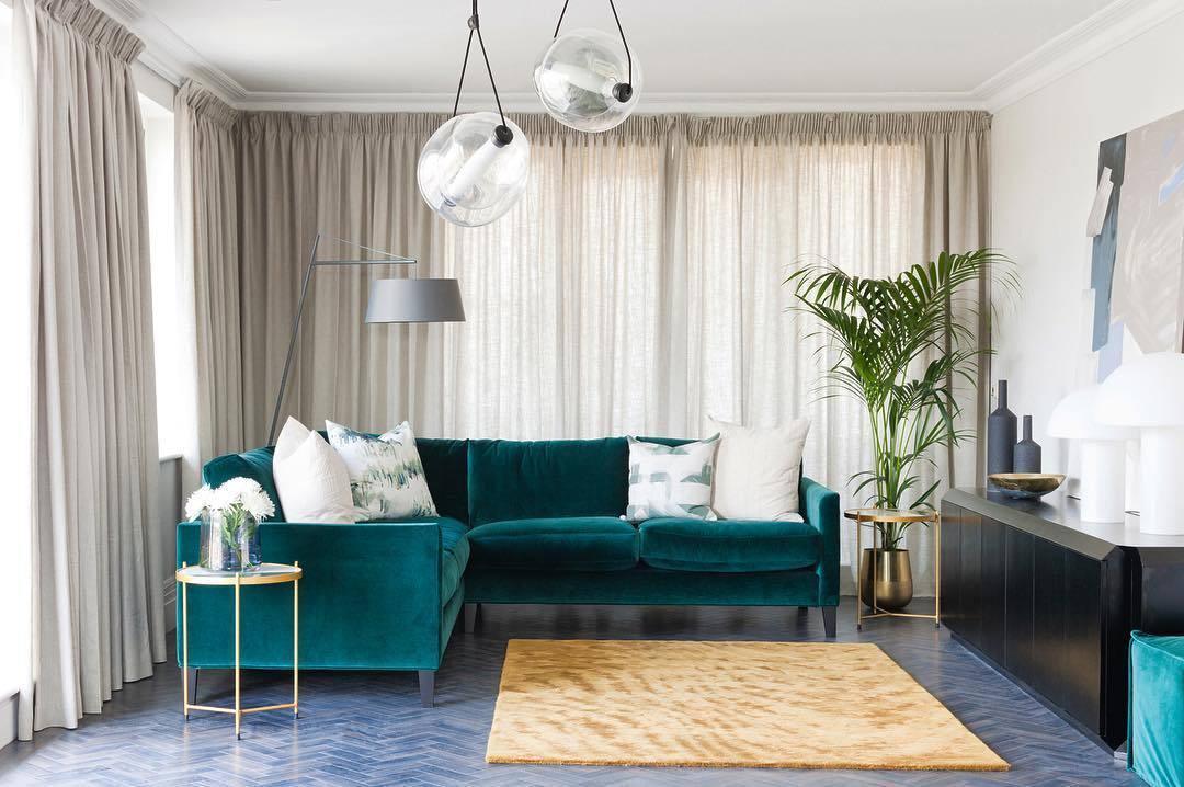 Clear glass pendants above a green sofa