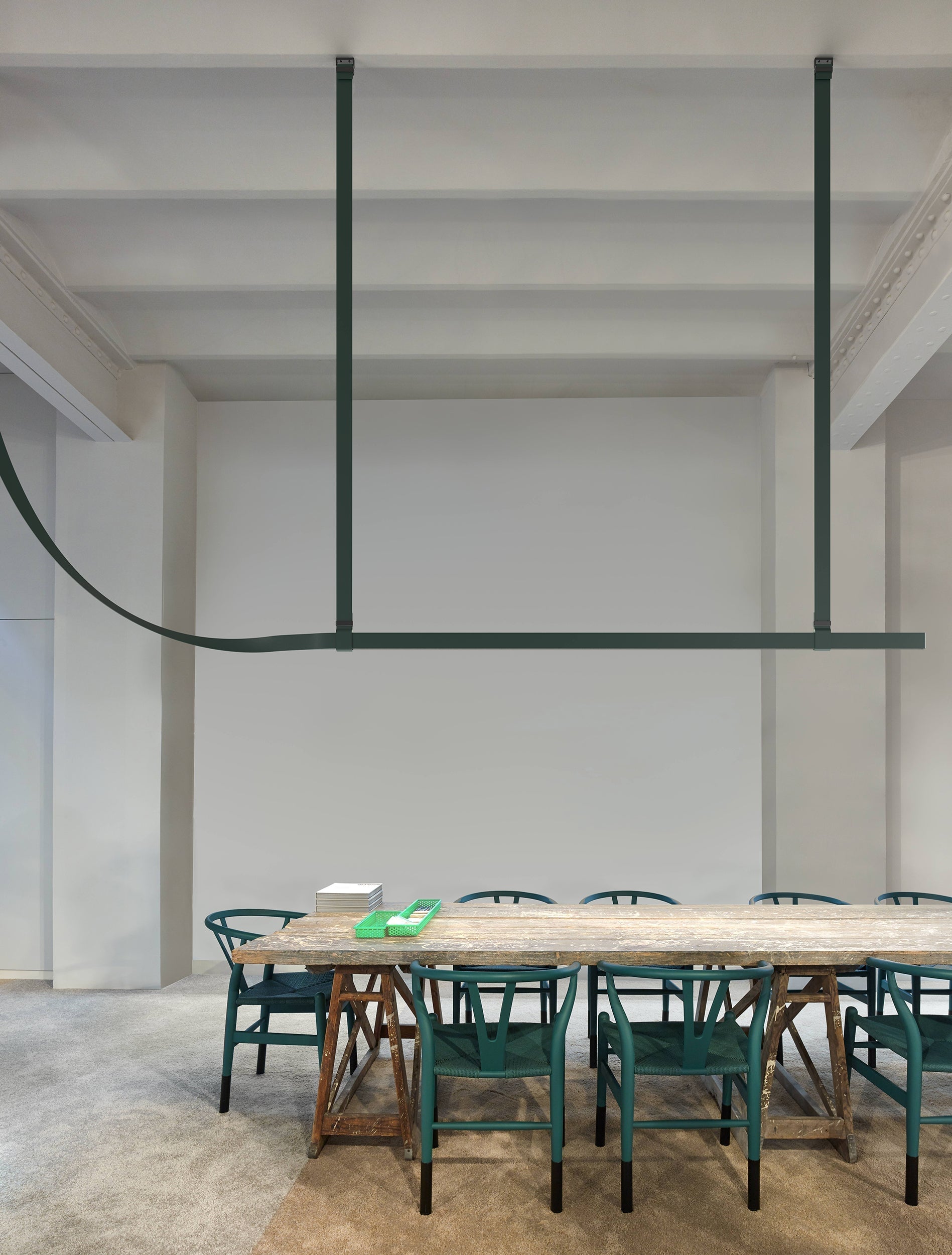 Dark green horizontal light profile and curved strap in a pale dining room