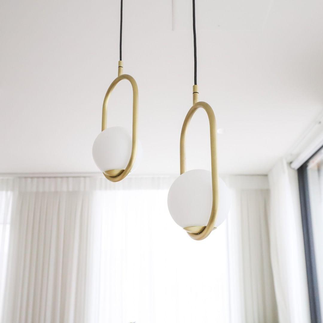 Close view of two oval brass-coloured frames and white globes