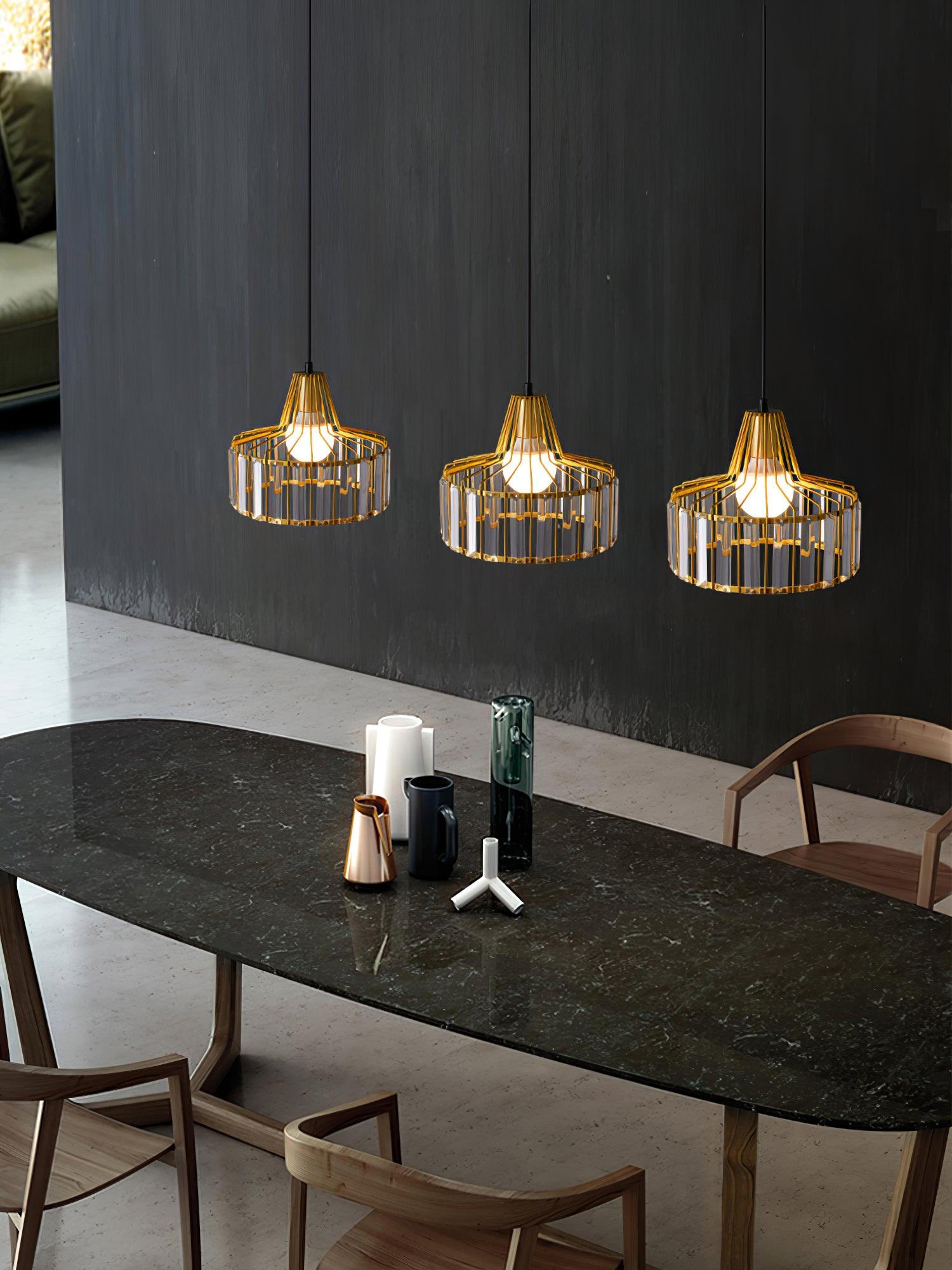Three gold-coloured drum pendants above a dark dining table
