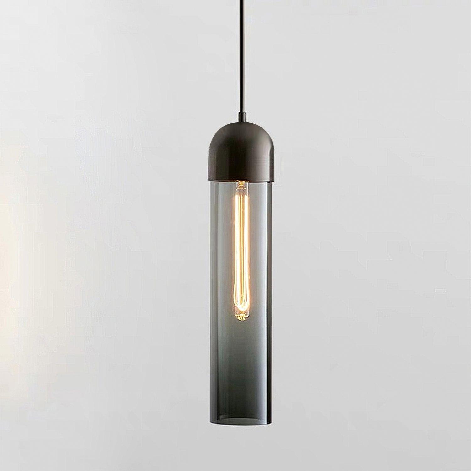 Close smoky glass cylinder pendant with dark rounded cap and glowing elongated bulb