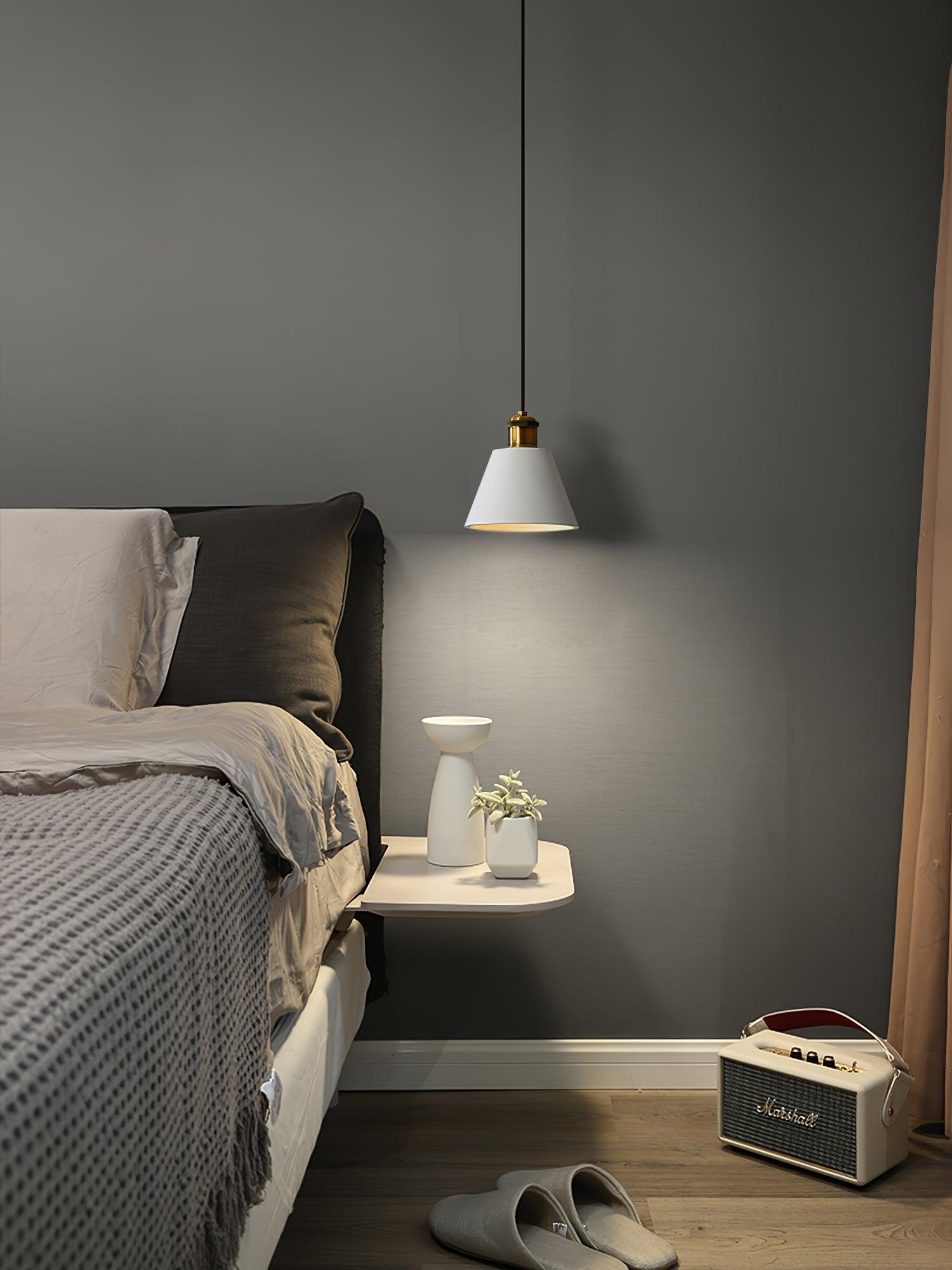 Cone pendant over a small bedroom side table