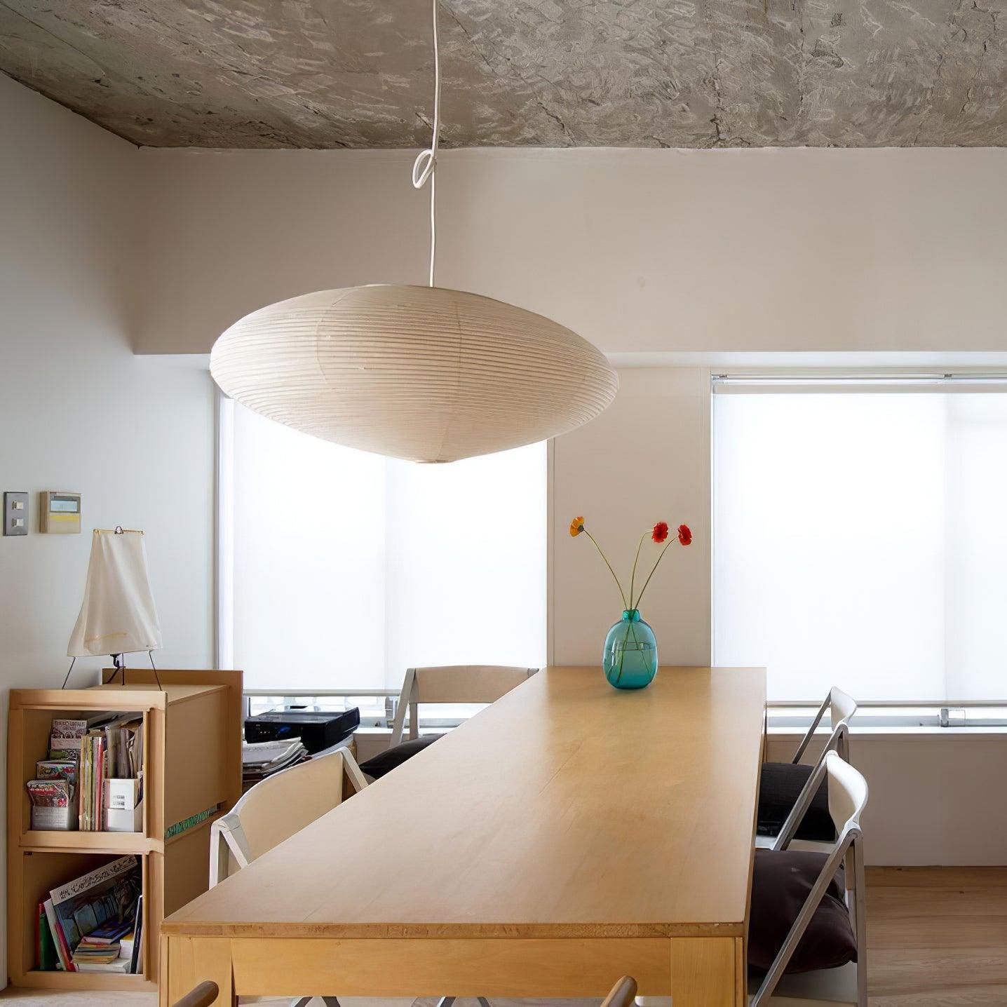White paper pendant with routed cord above a wooden table