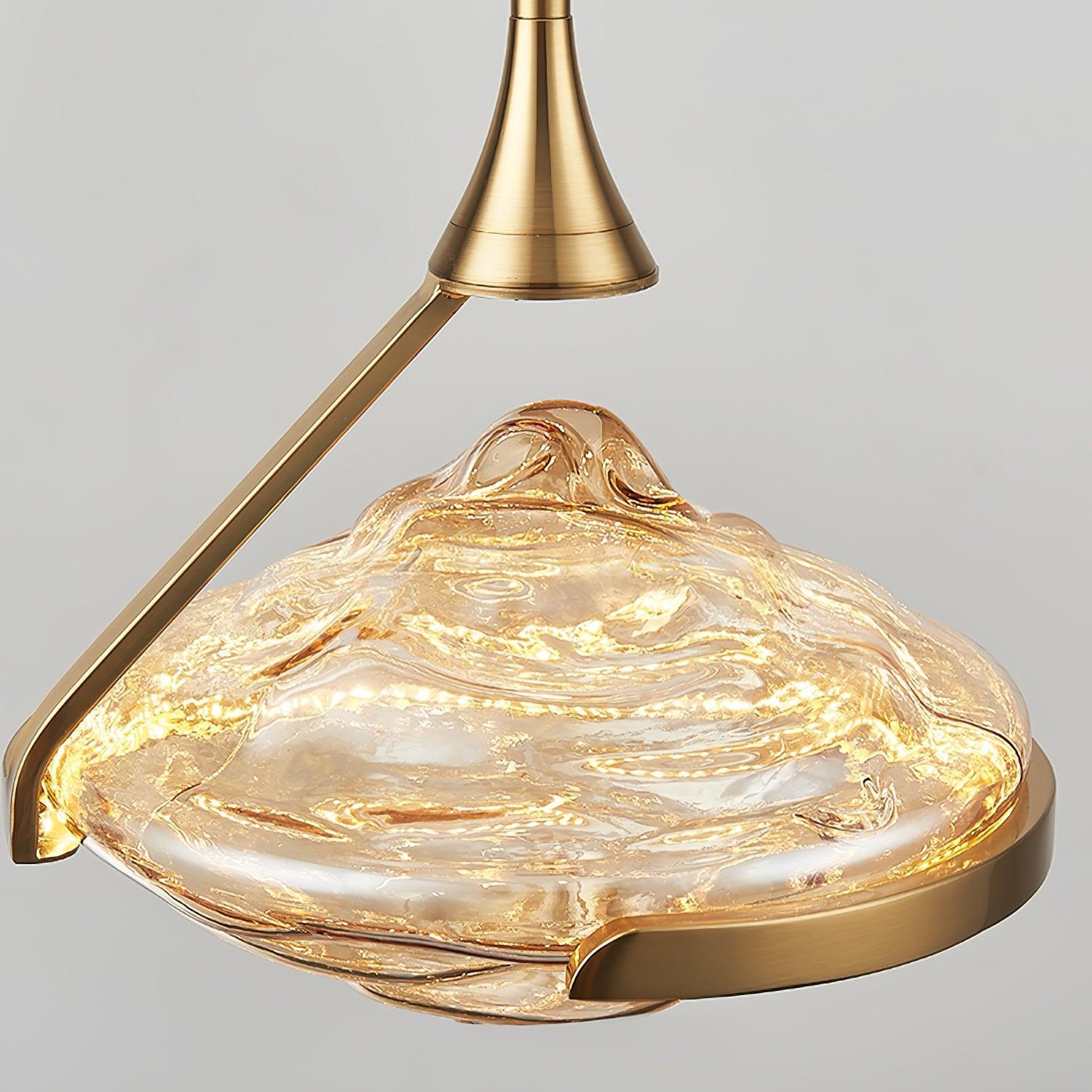 Frontal close-up of illuminated rippled glass with gold-toned head, diagonal arm and curved open cradle