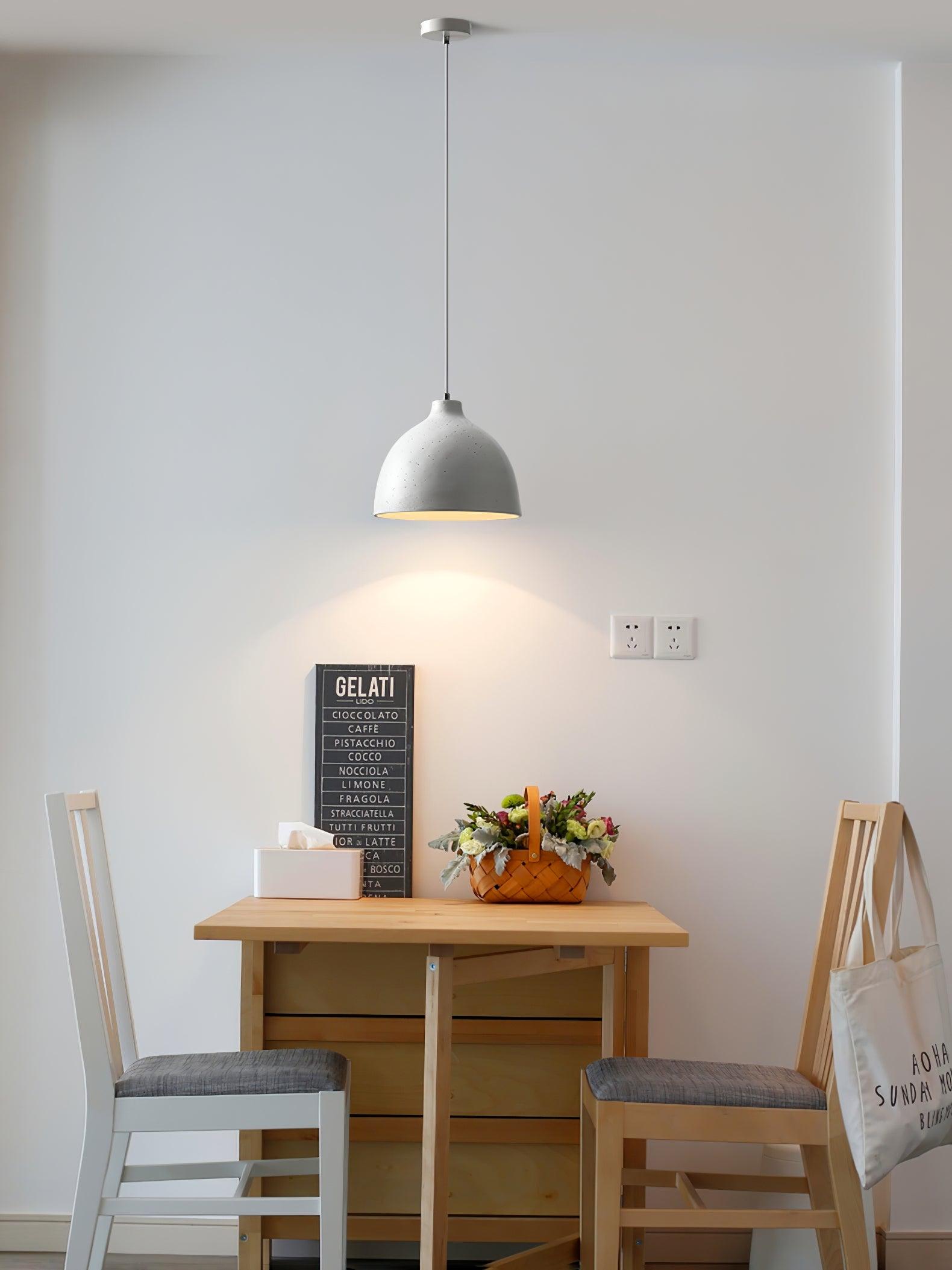 White pendant over a small wooden dining table