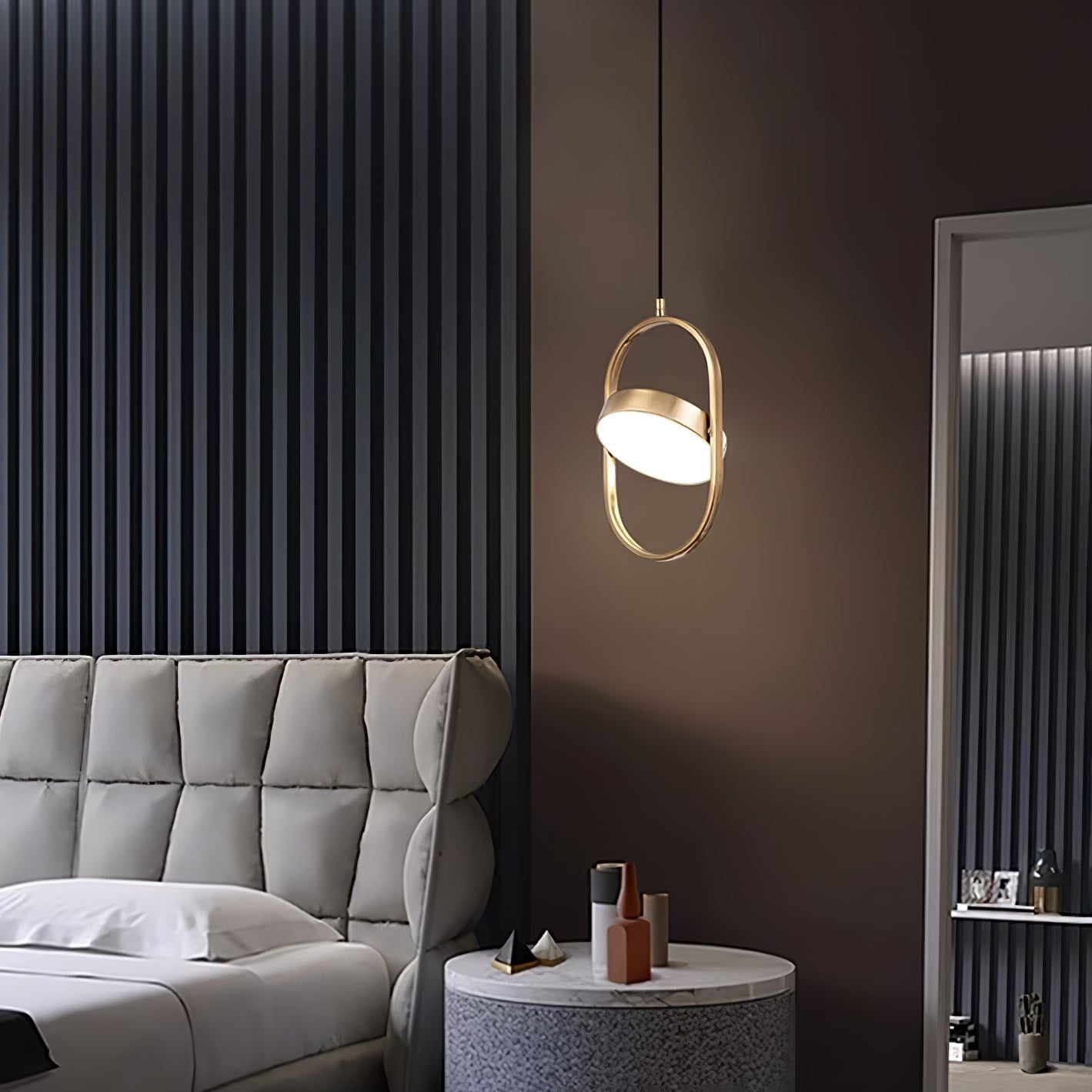 Gold vertical KUU pendant beside a bed