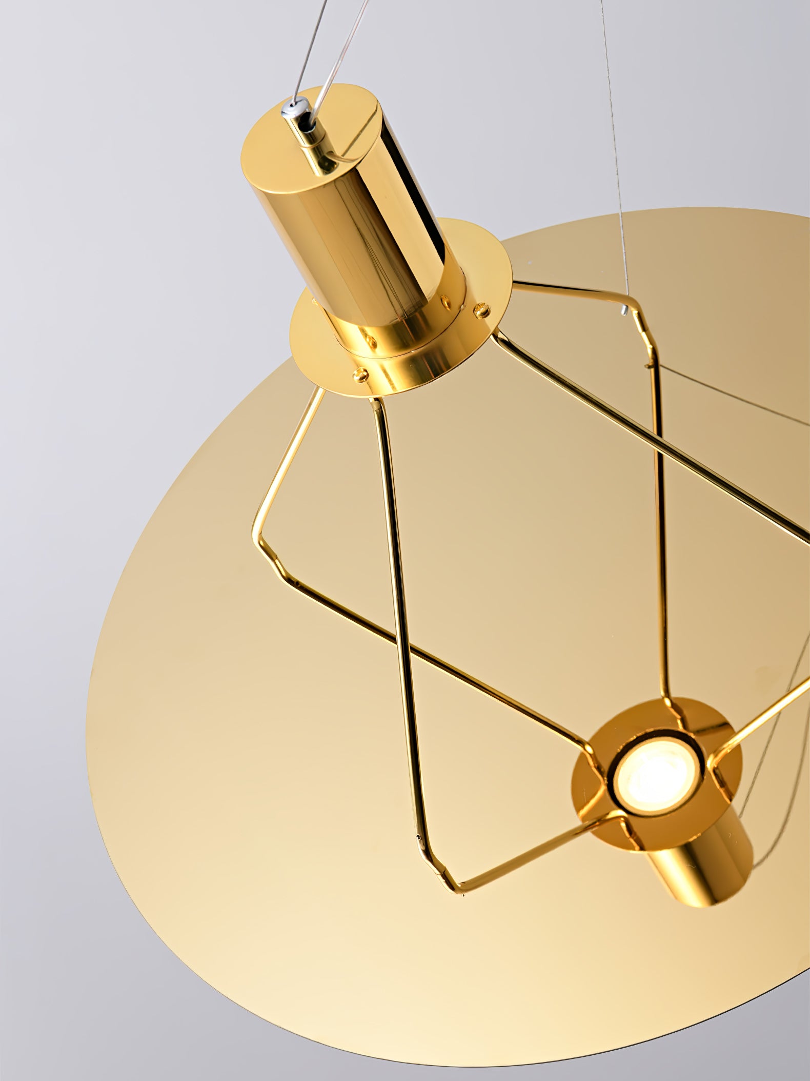 Gold cylindrical light head facing the round reflector