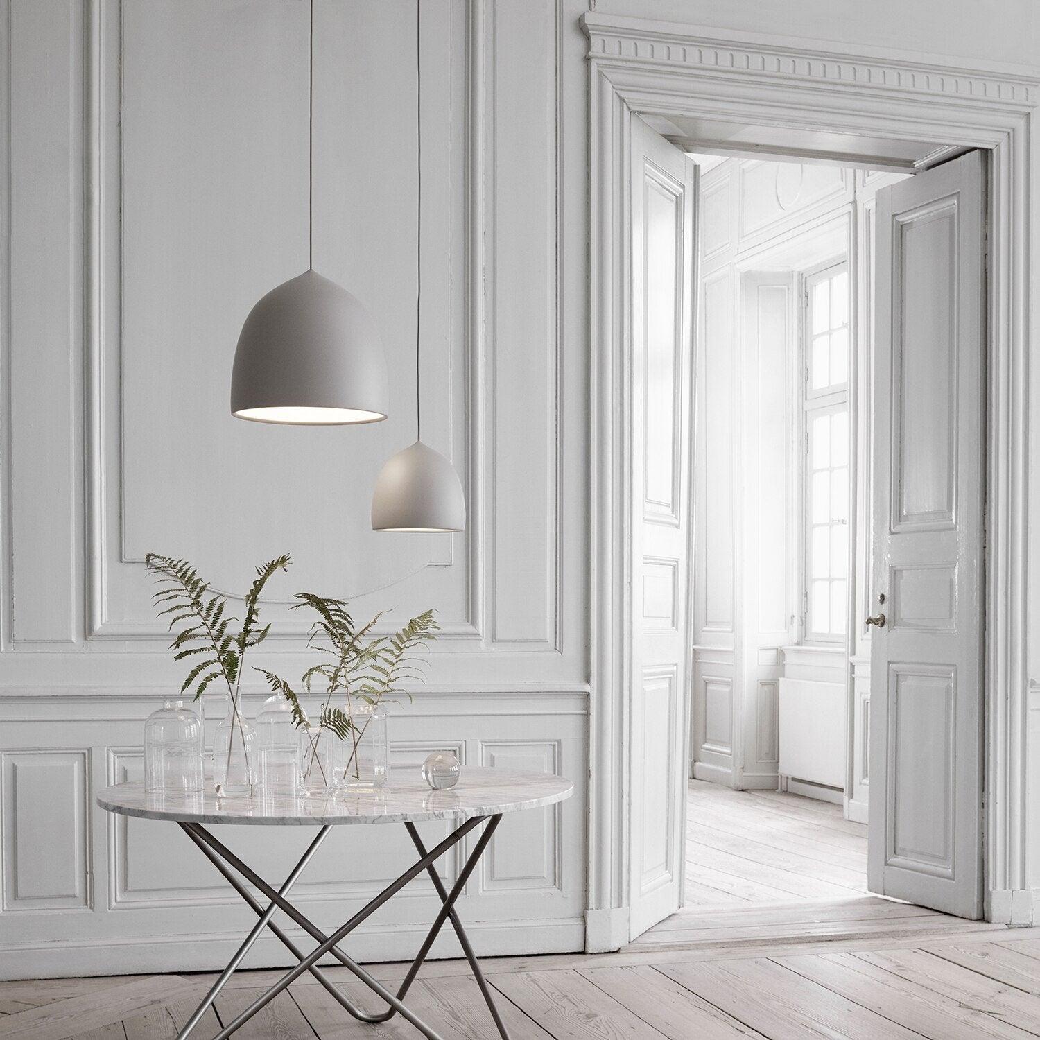 Grey bell pendant and its reflection in a large mirror