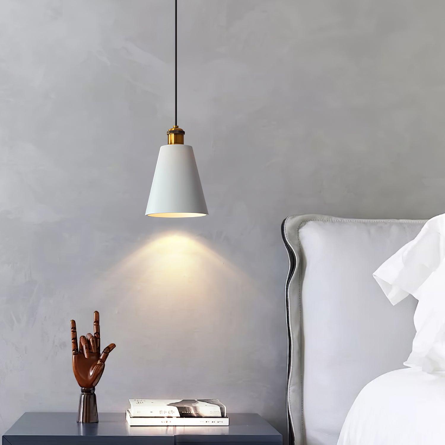 White cone pendant beside a bed