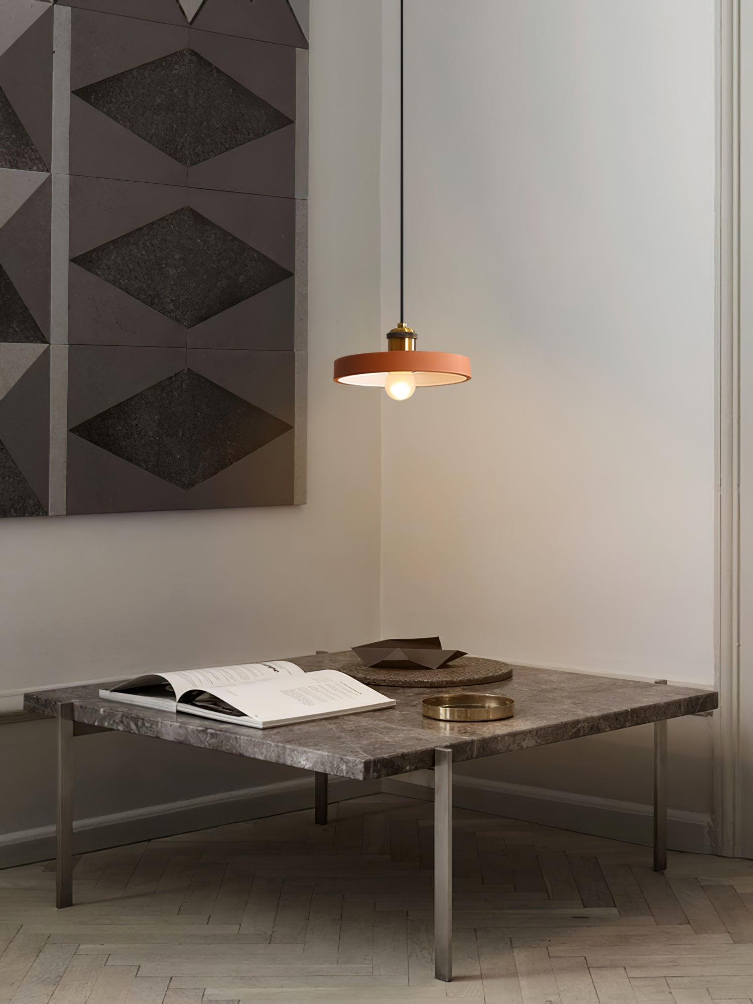 Orange disc pendant above a small table
