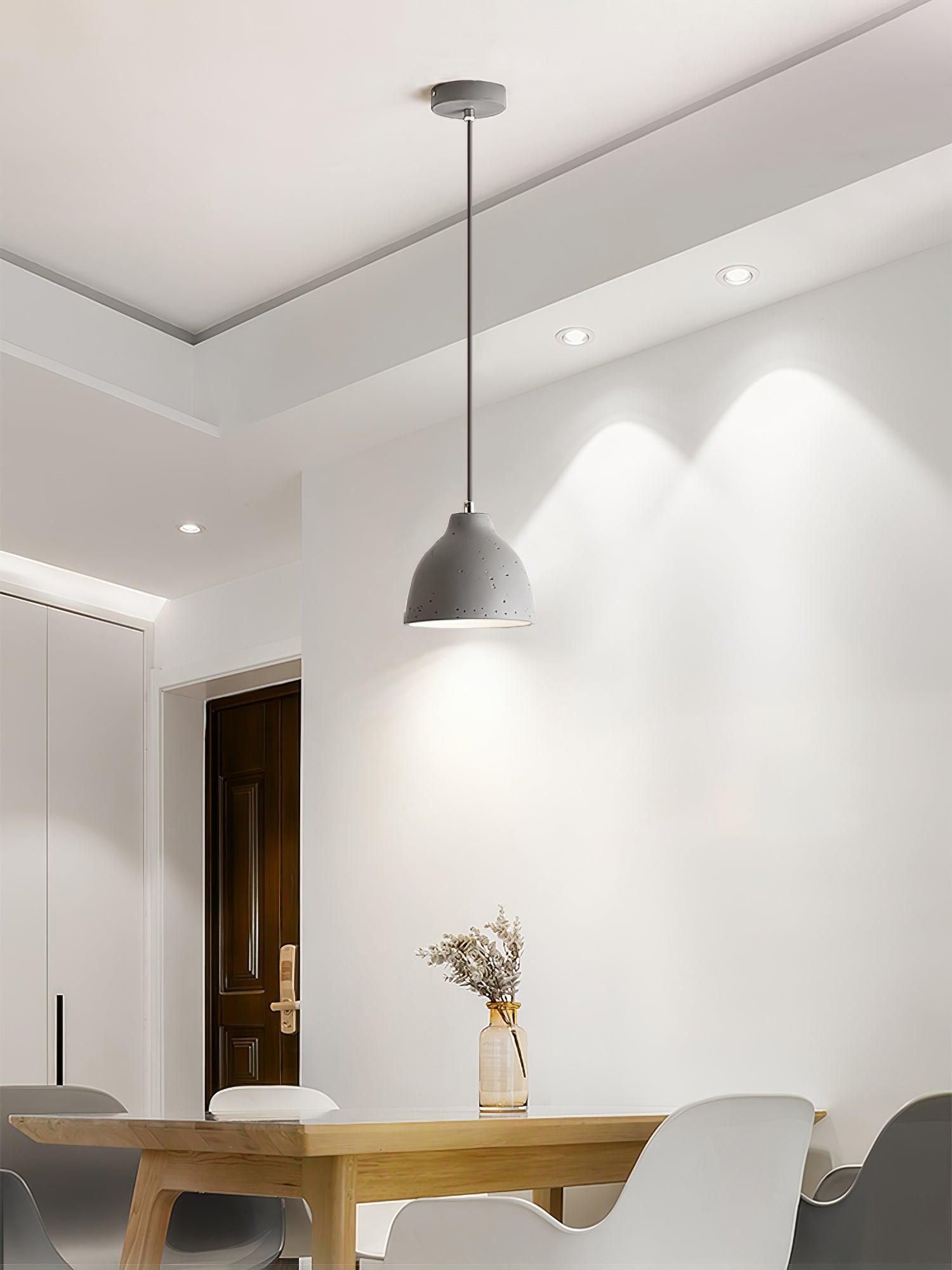 Grey pendant above a light wooden table