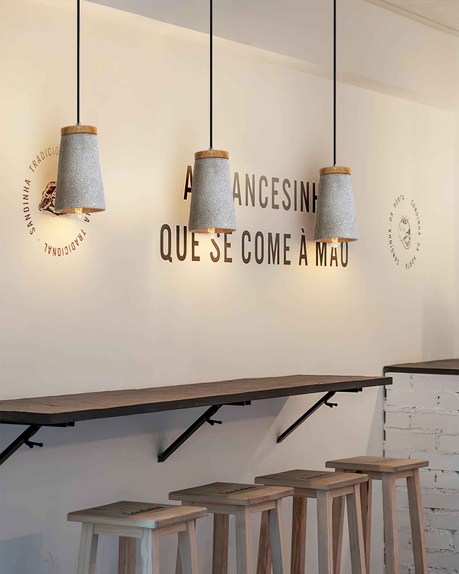 Wood-topped cement pendants above a café counter
