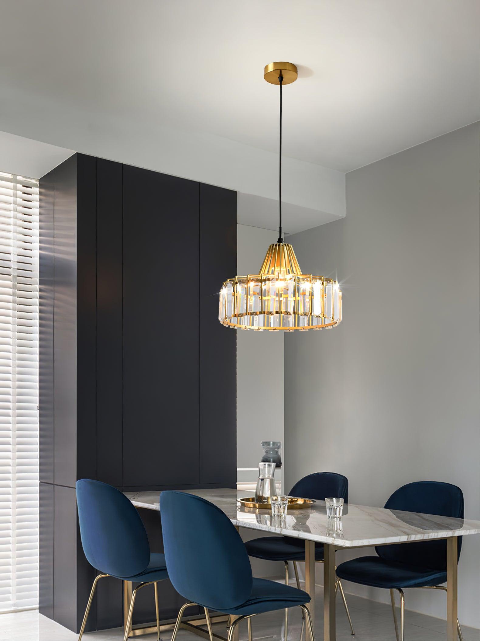 Gold-coloured pendant above a table with blue chairs