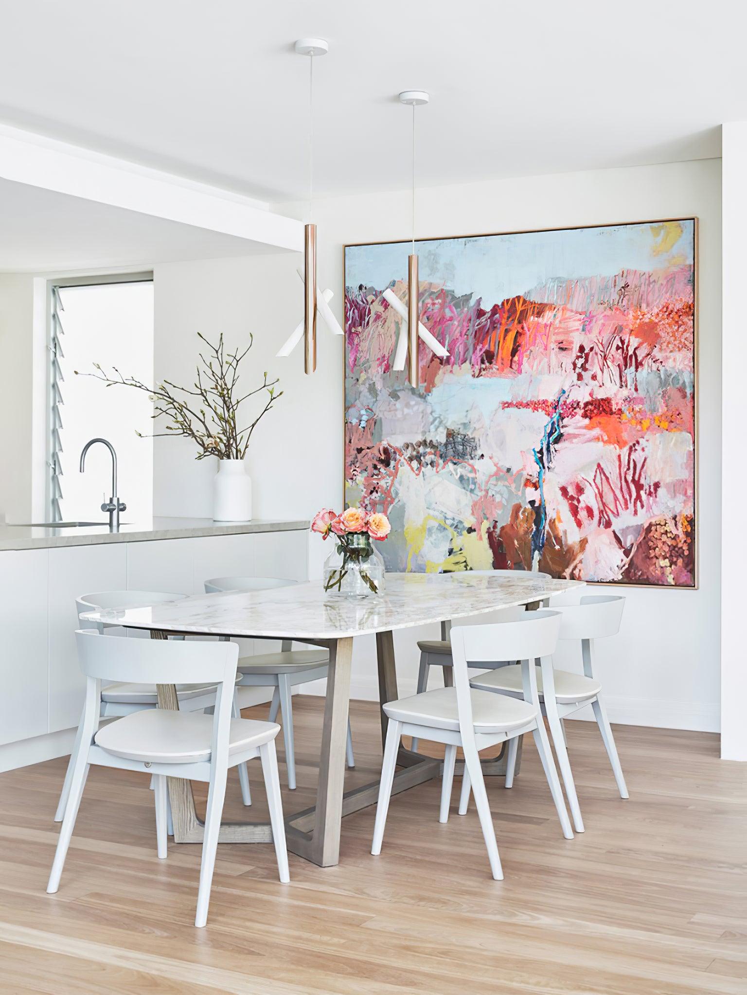 White Tubes pendants above a dining table in a bright room with colourful wall art