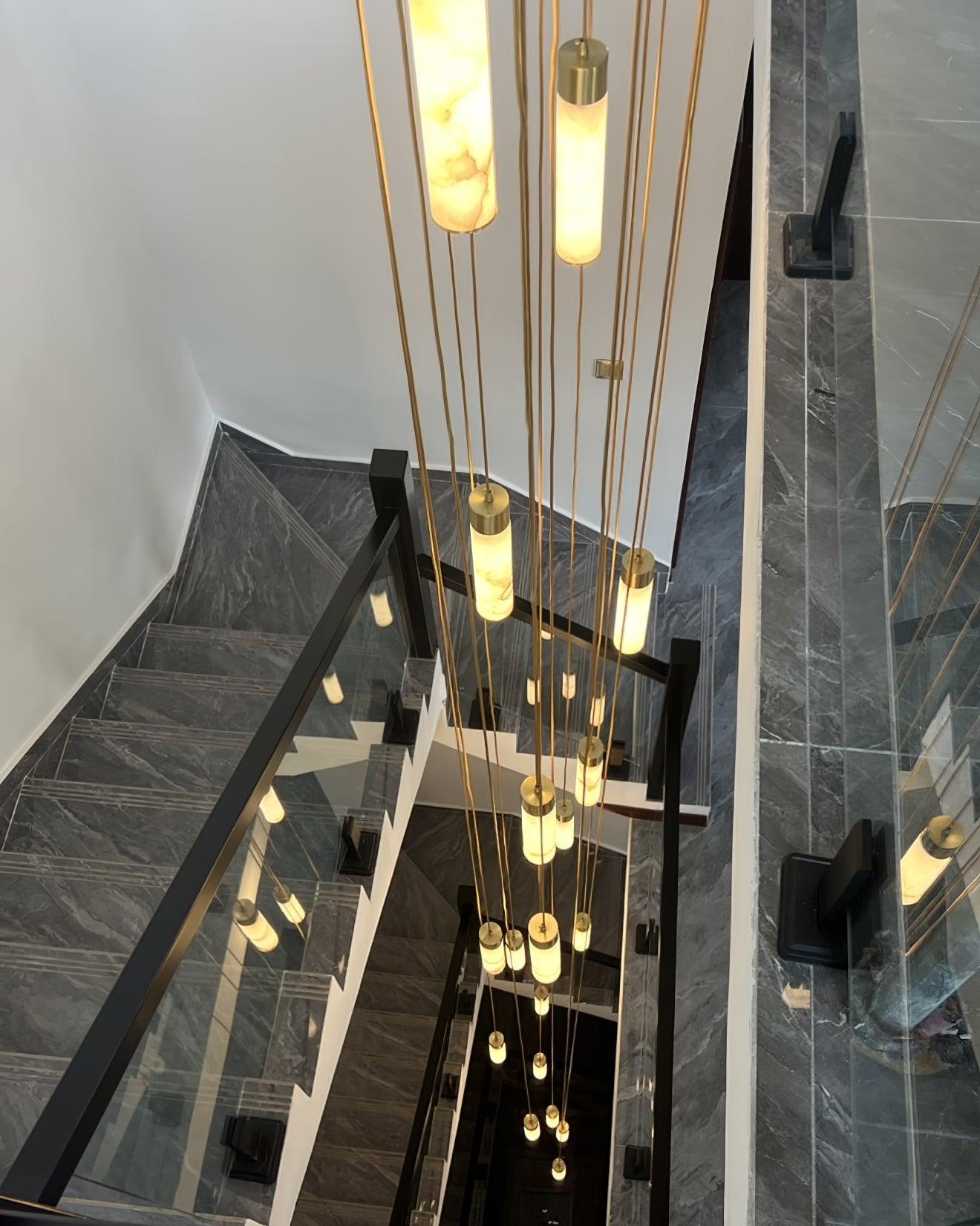 Many slim stone pendants suspended through a stairwell