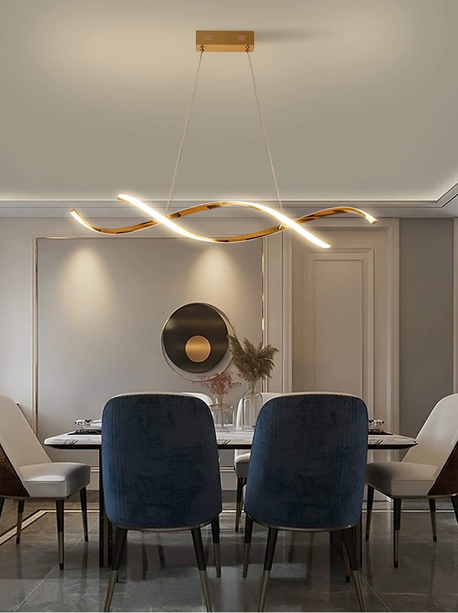 Gold wave pendant above a dark dining table with blue upholstered chairs against a panelled wall