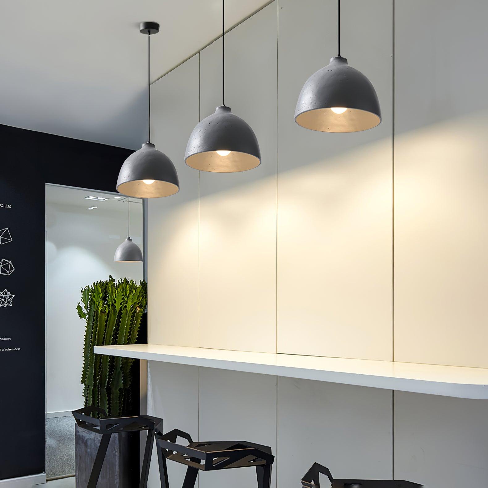 Three grey bowl pendants along a counter