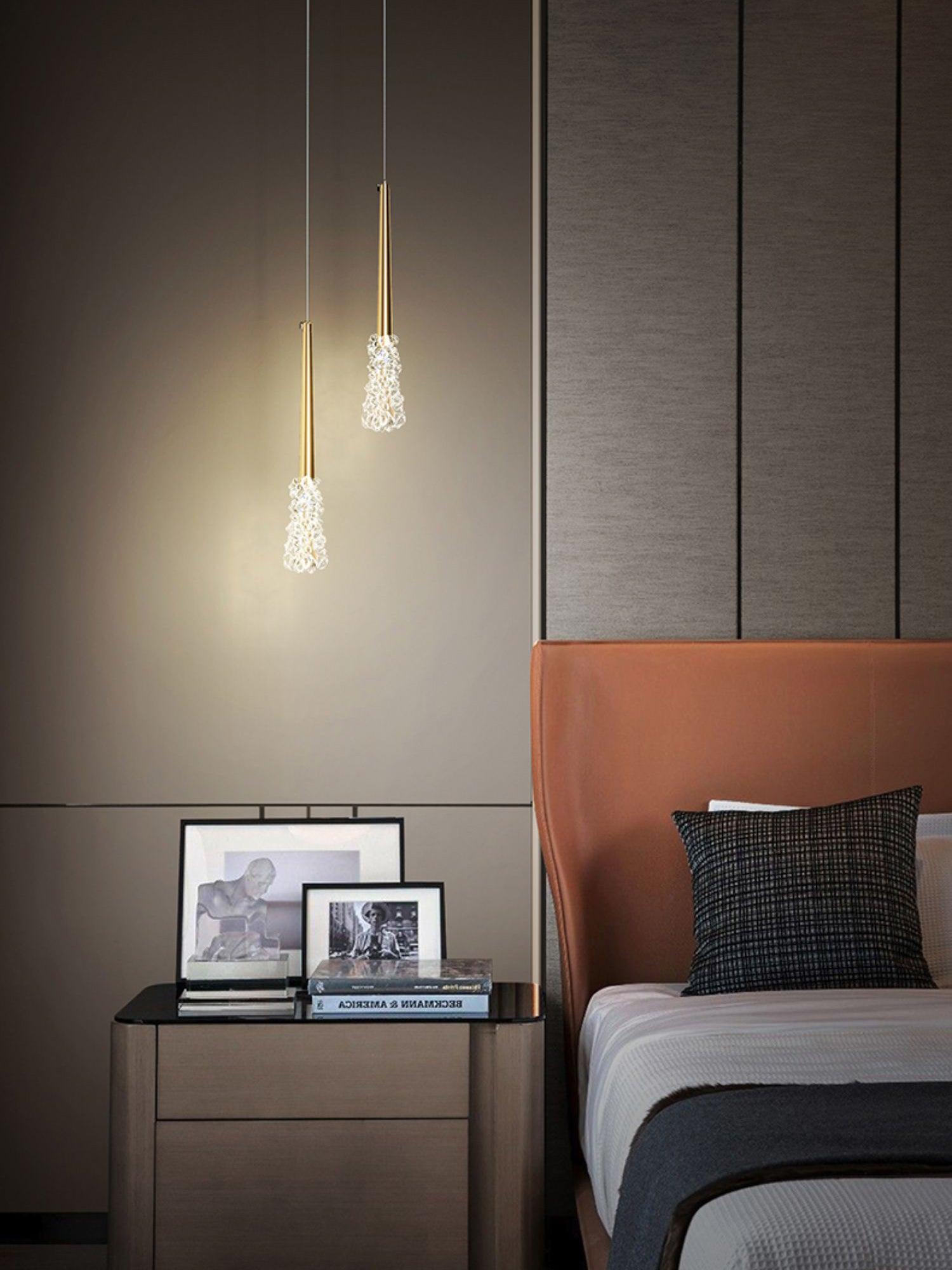 Gold pendant pair near a bedroom headboard