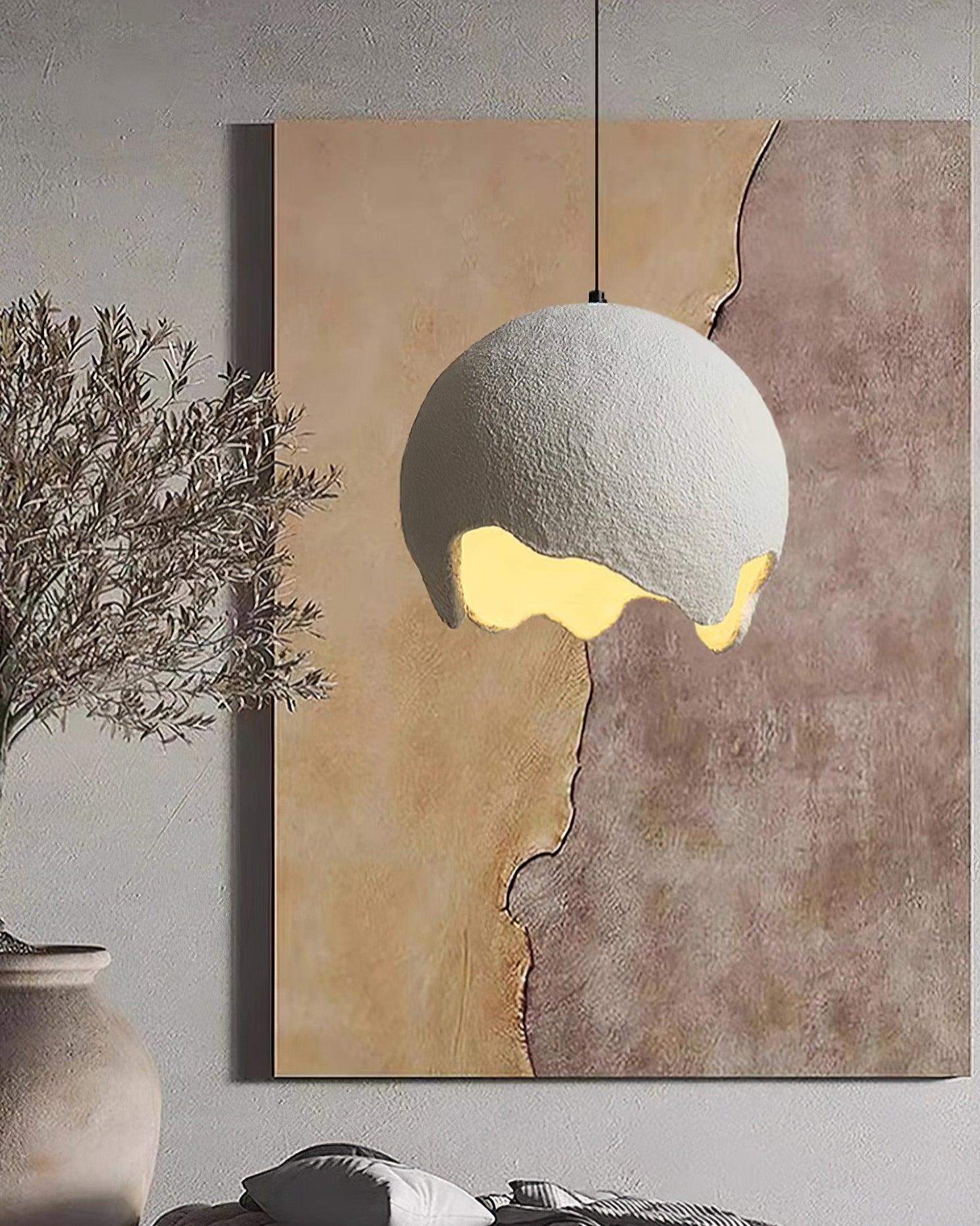White textured globe pendant beside abstract artwork
