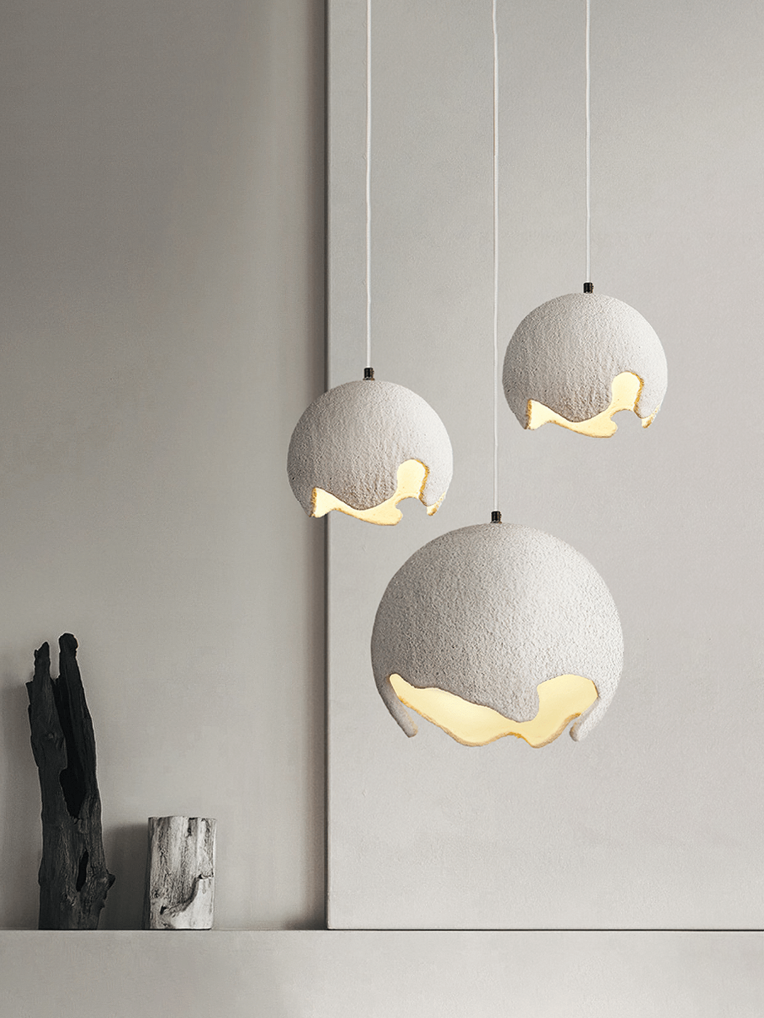 Three white textured globe pendants in a staggered group