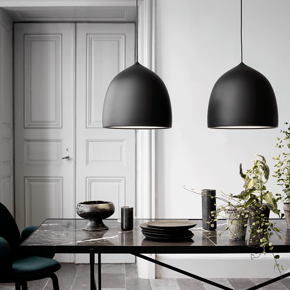 Two black bell pendants above a dark table