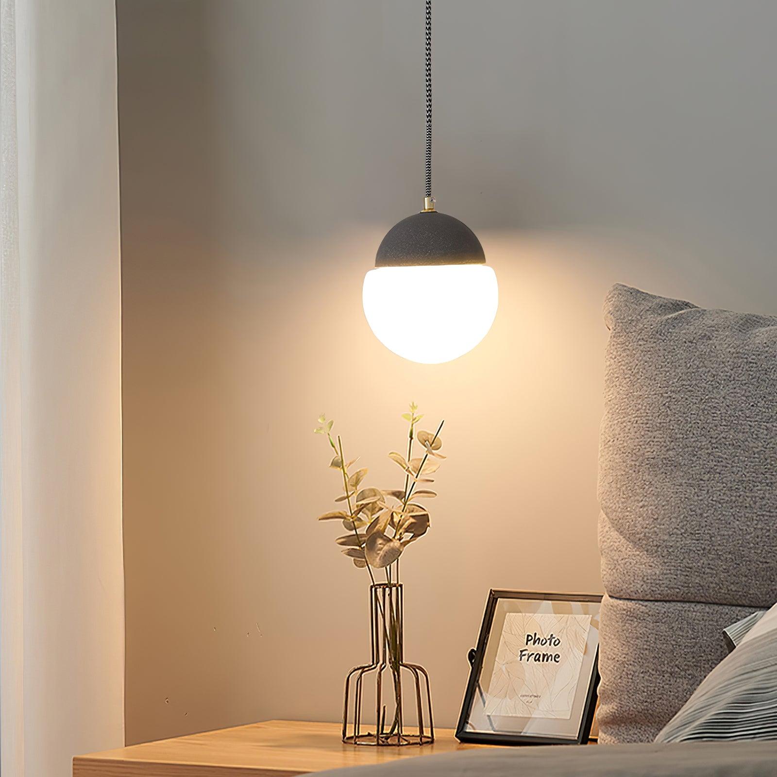 Dark-capped White globe pendant at a bedside