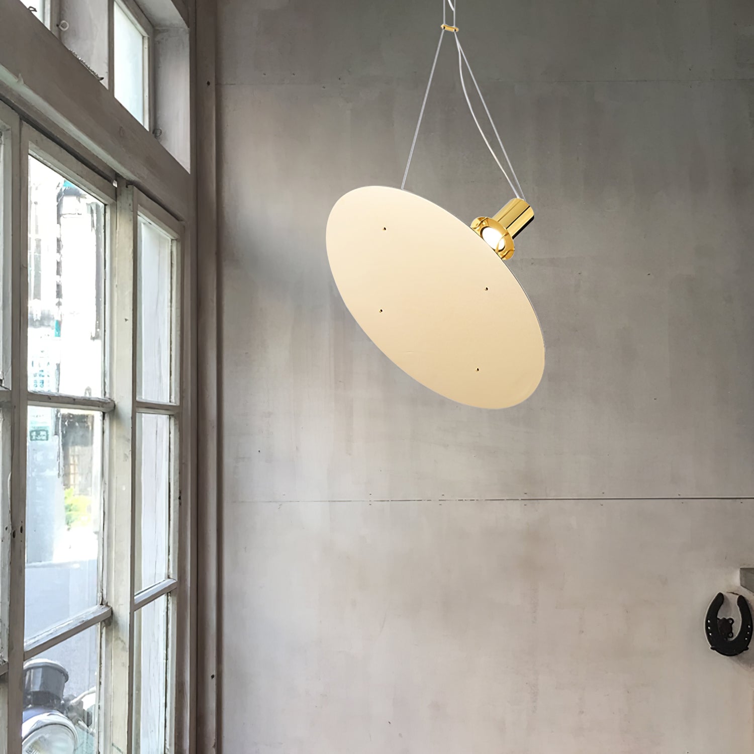 Pale Gold disc hanging beside a large window