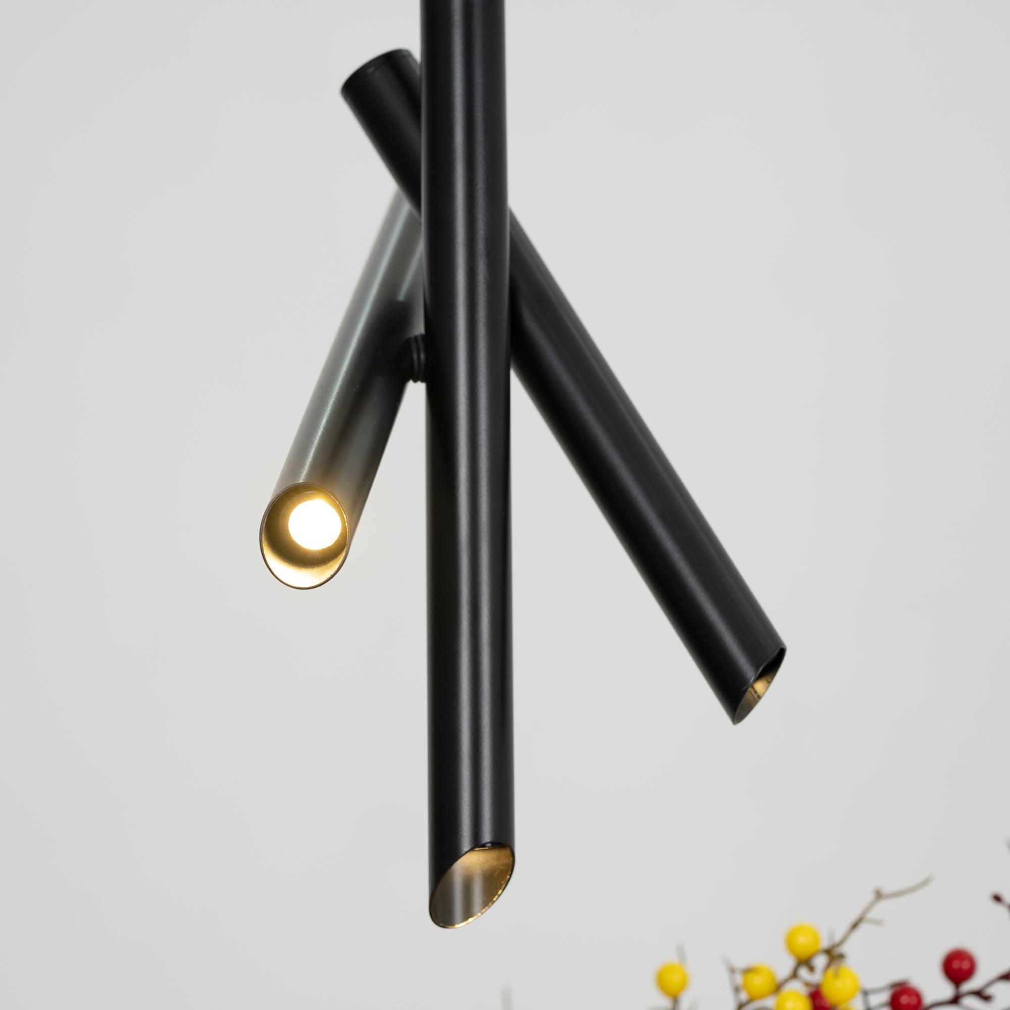 Angled close-up of a black Tubes pendant with light visible at a tubular end