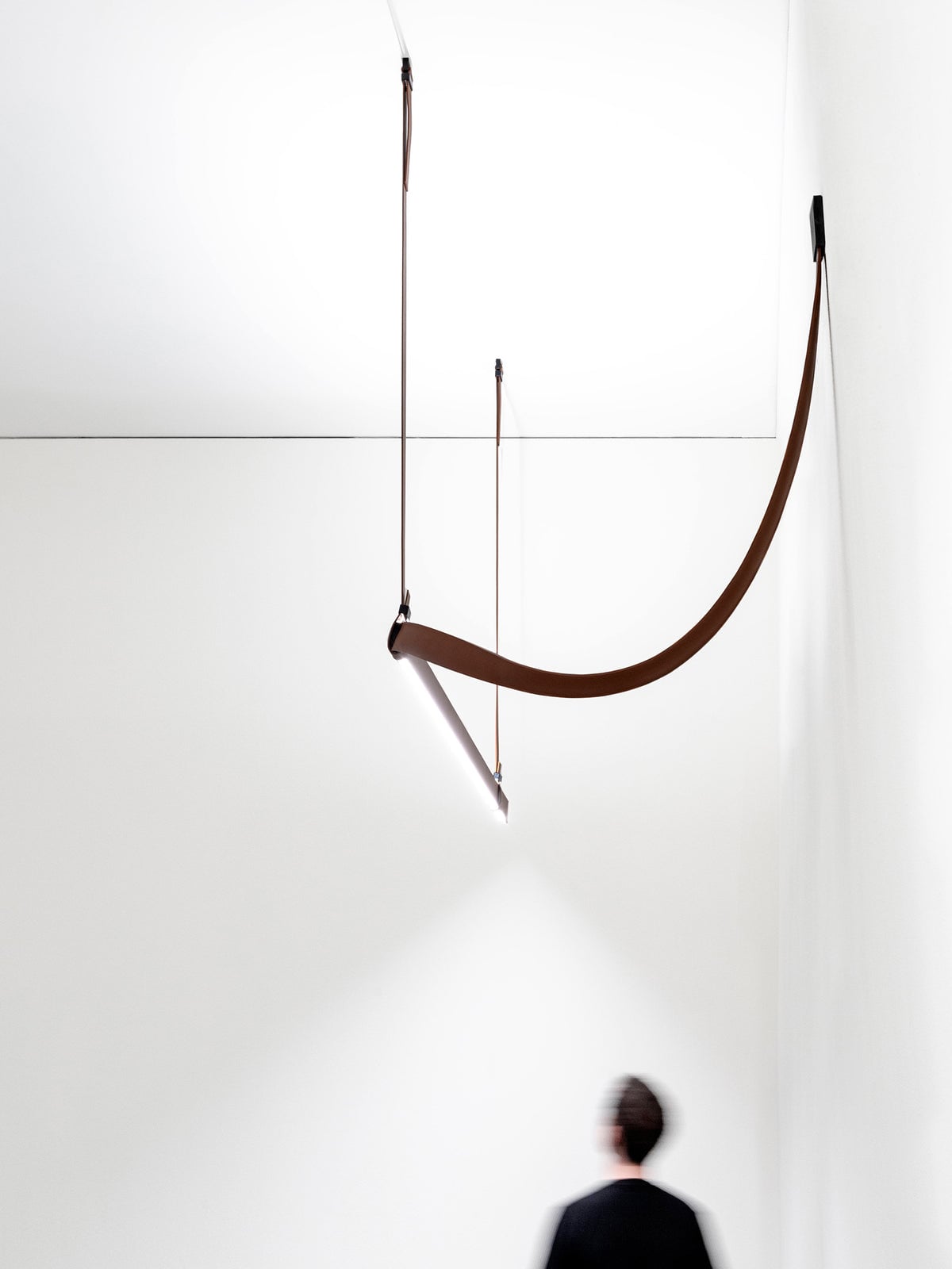 Long curved strap and linear light viewed from below